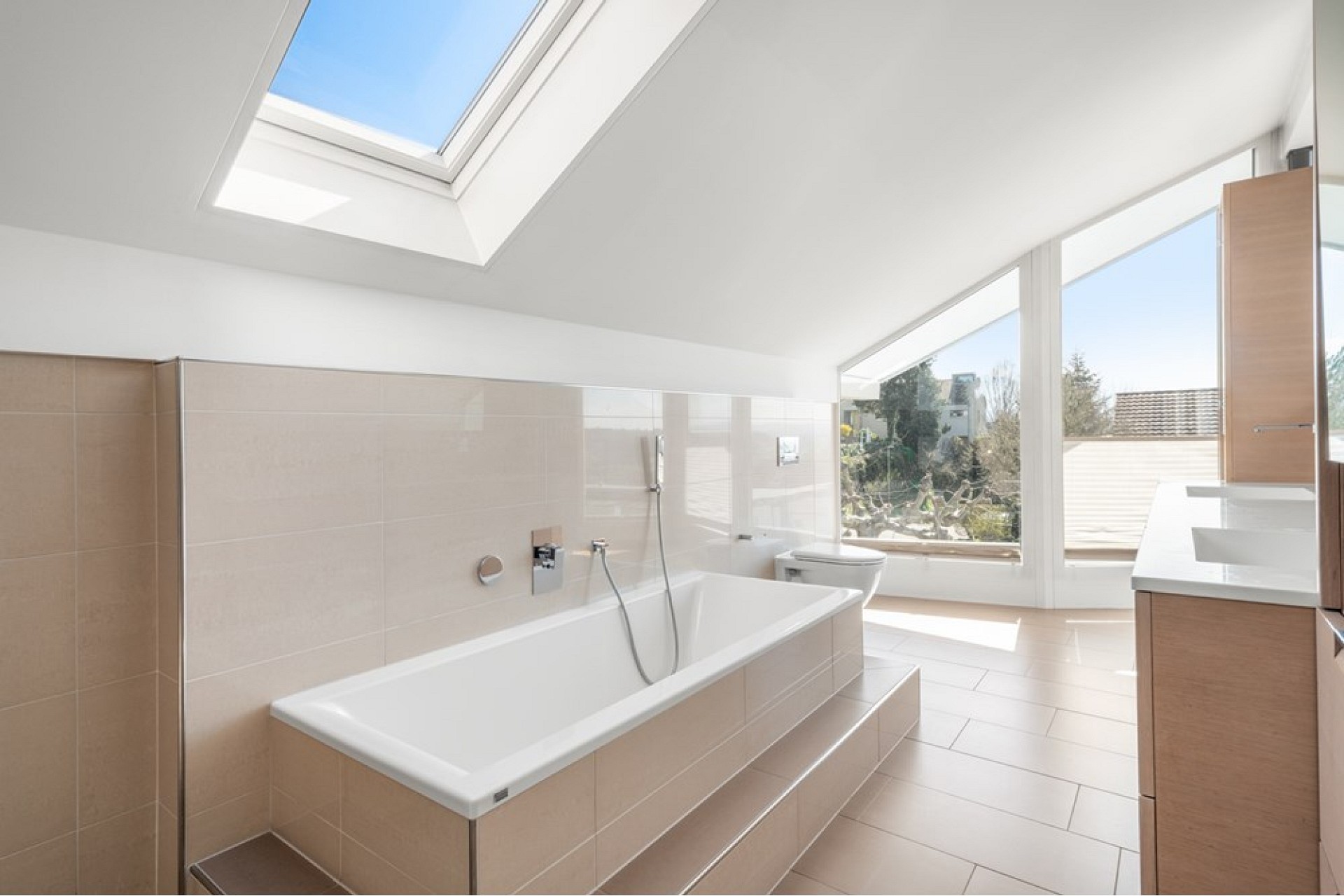 Helles Badezimmer mit Dachfenster und Badewanne
