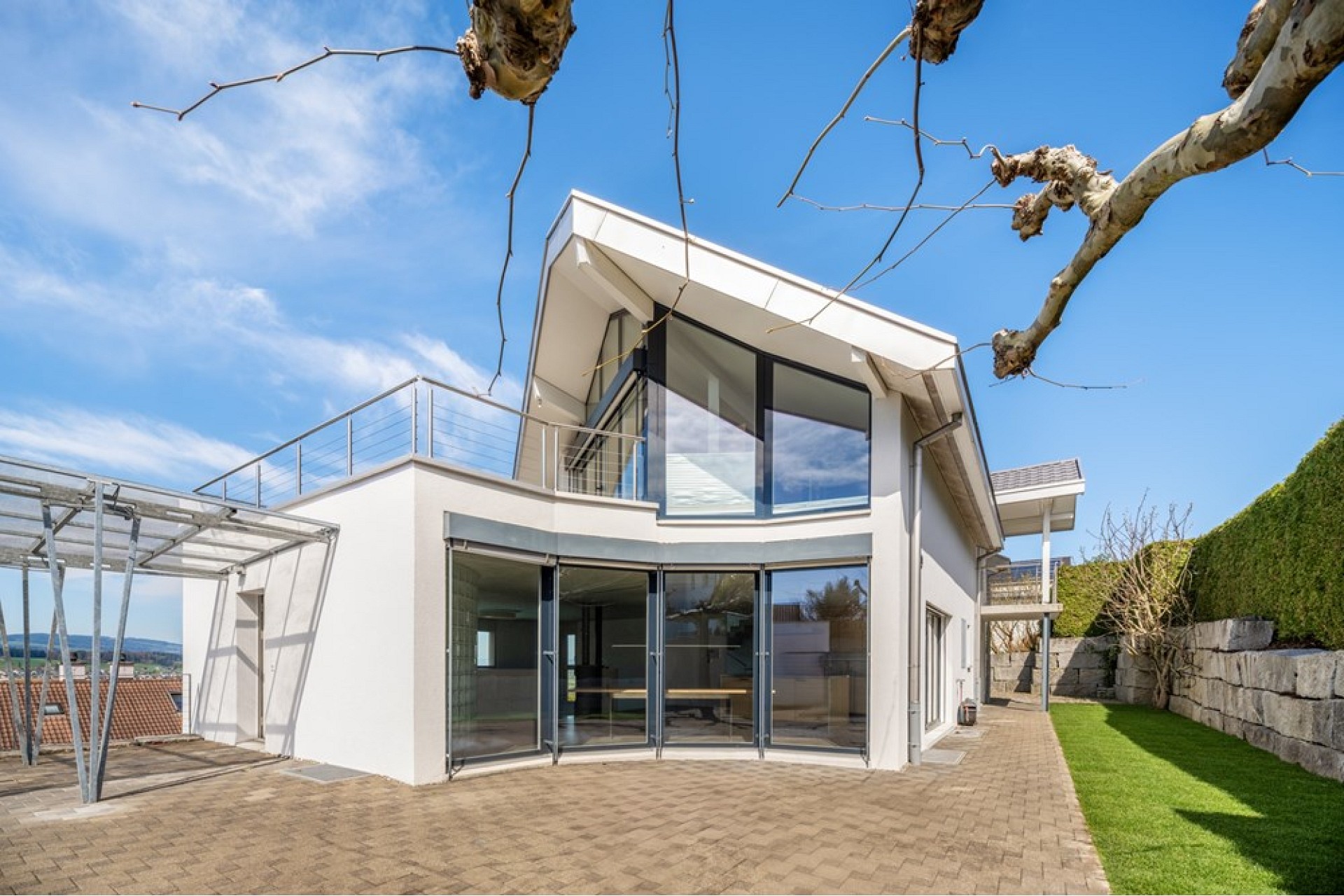 Modernes Einfamilienhaus mit großer Verglasung und Dachterrasse