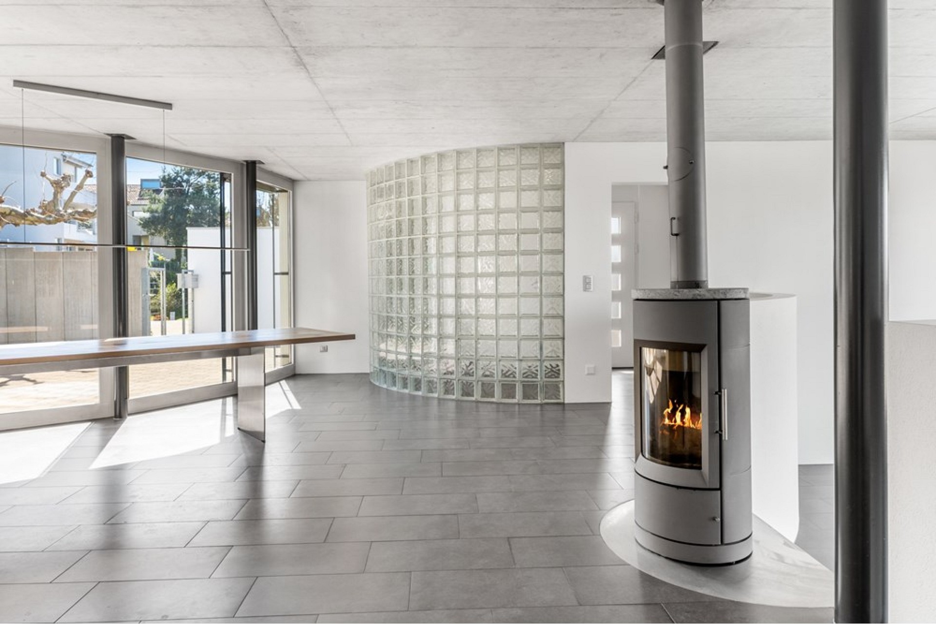 Offener Wohnraum mit Kamin und Glasbausteinwand