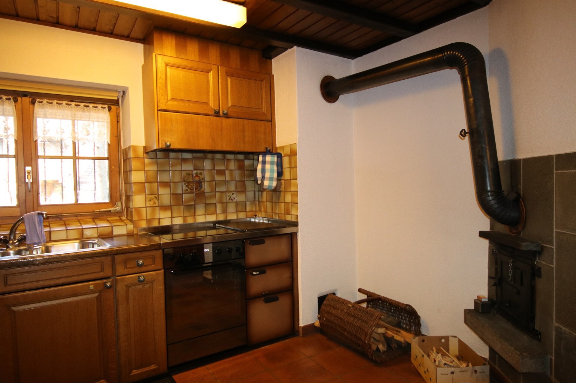 Gemütliche Küche mit Holzfronten und Kaminofen