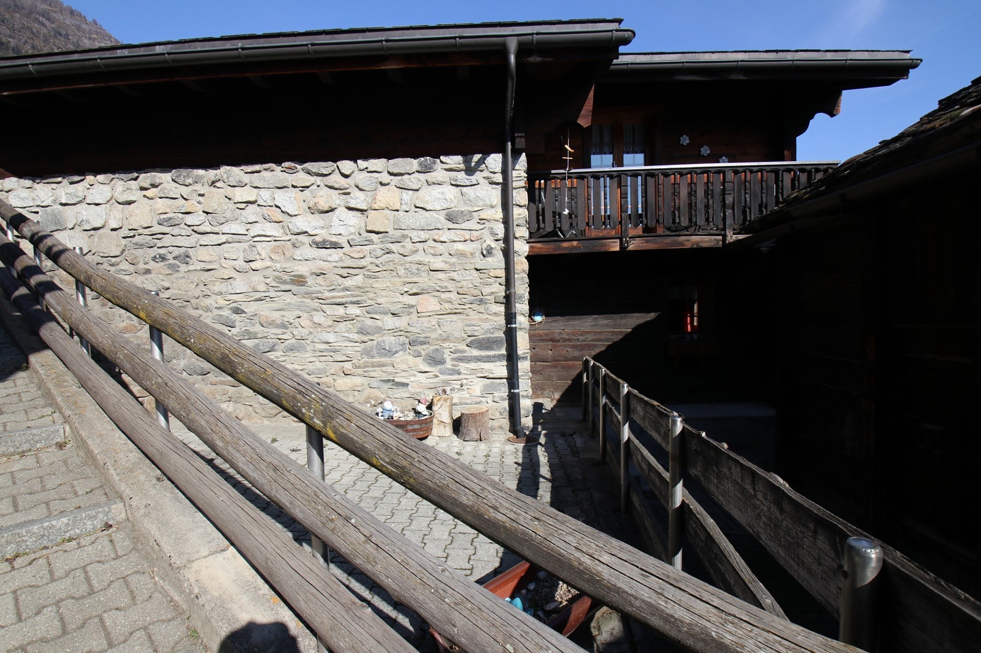 Alpenhaus mit Steinmauer und Holzgeländern