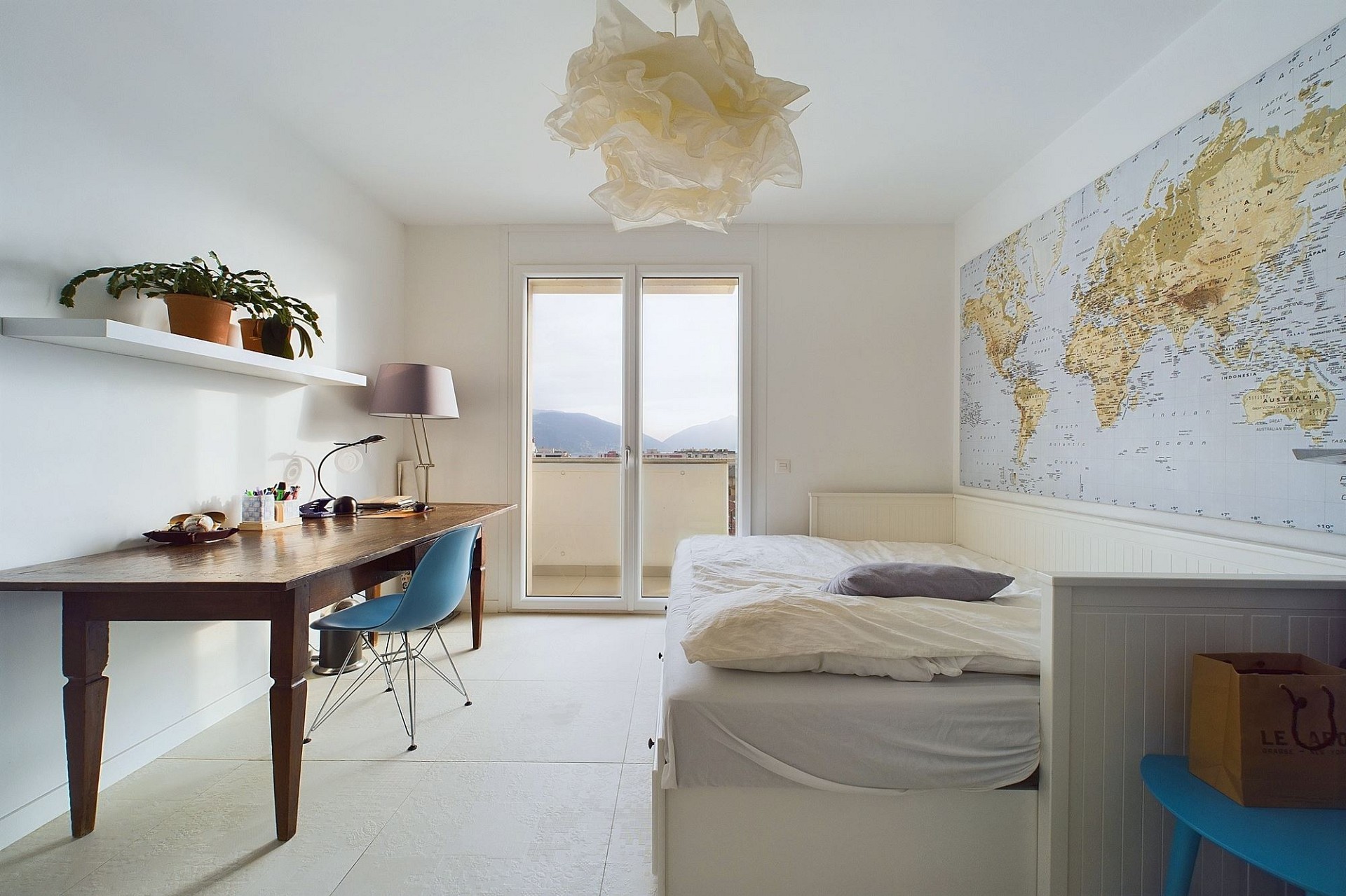 Helles Schlafzimmer mit Arbeitsbereich und Balkonzugang