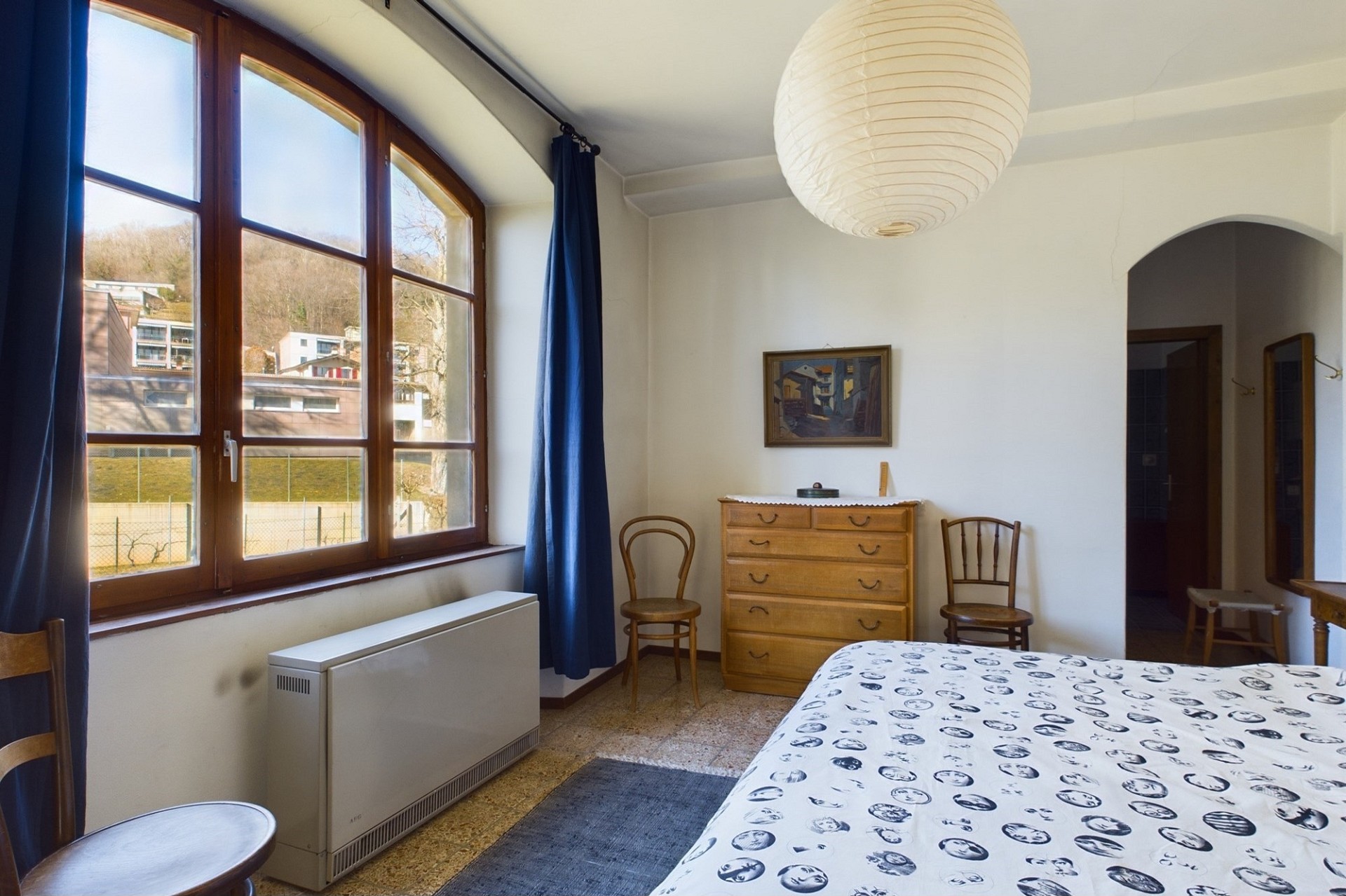 Helles Schlafzimmer mit großem Bogenfenster