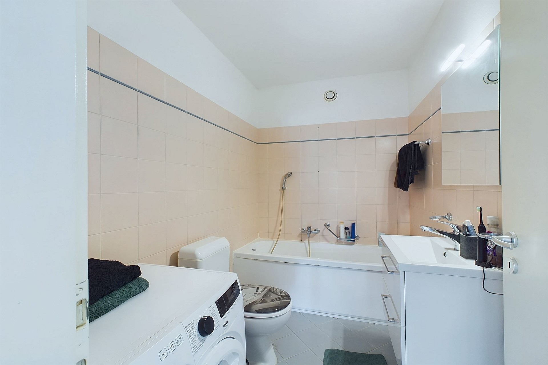 Badezimmer mit Badewanne und Waschmaschine