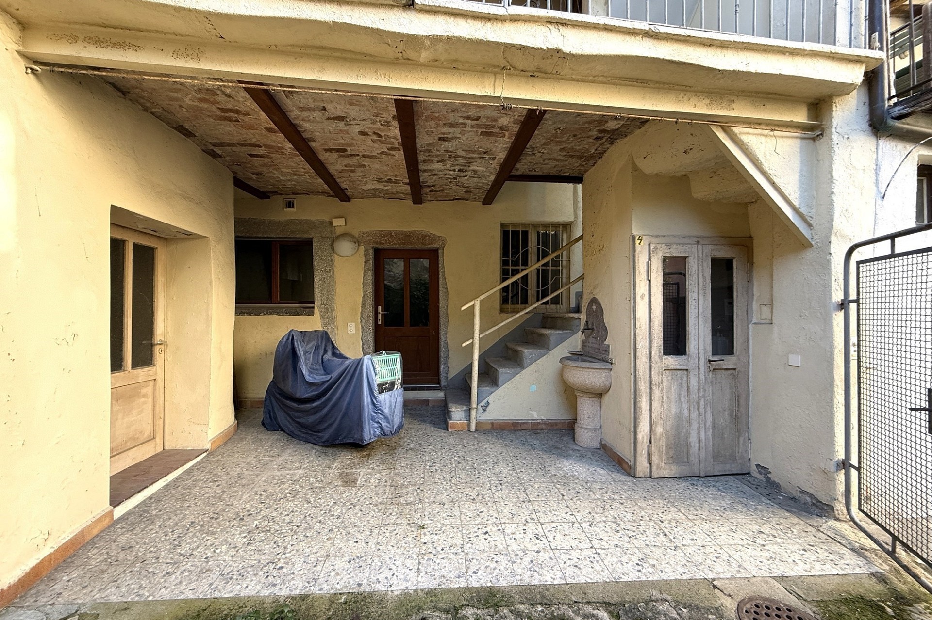 Überdachter Innenhof mit Treppe und Nebeneingängen