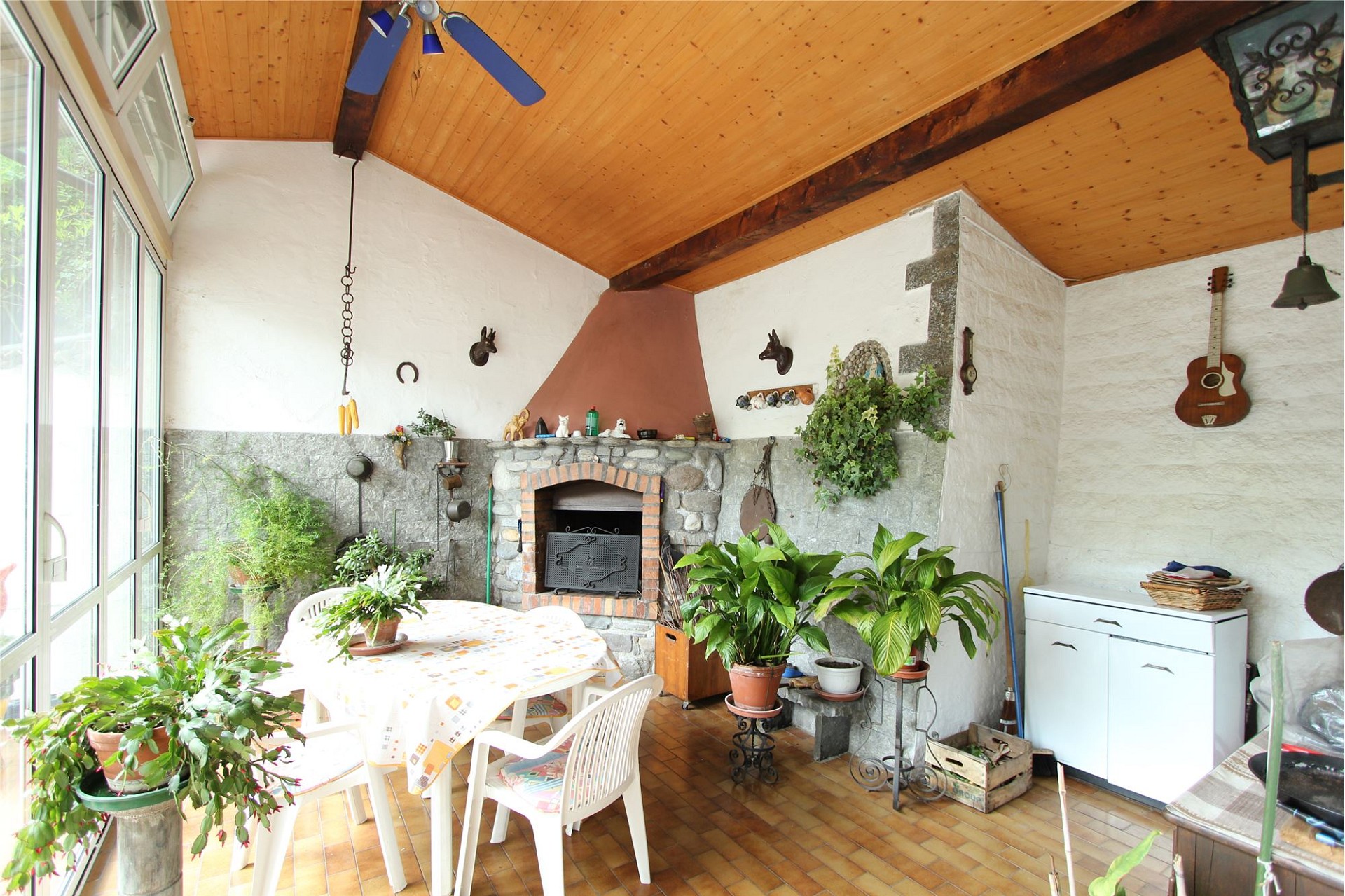 Gemütlicher Wintergarten mit Kamin und Pflanzen