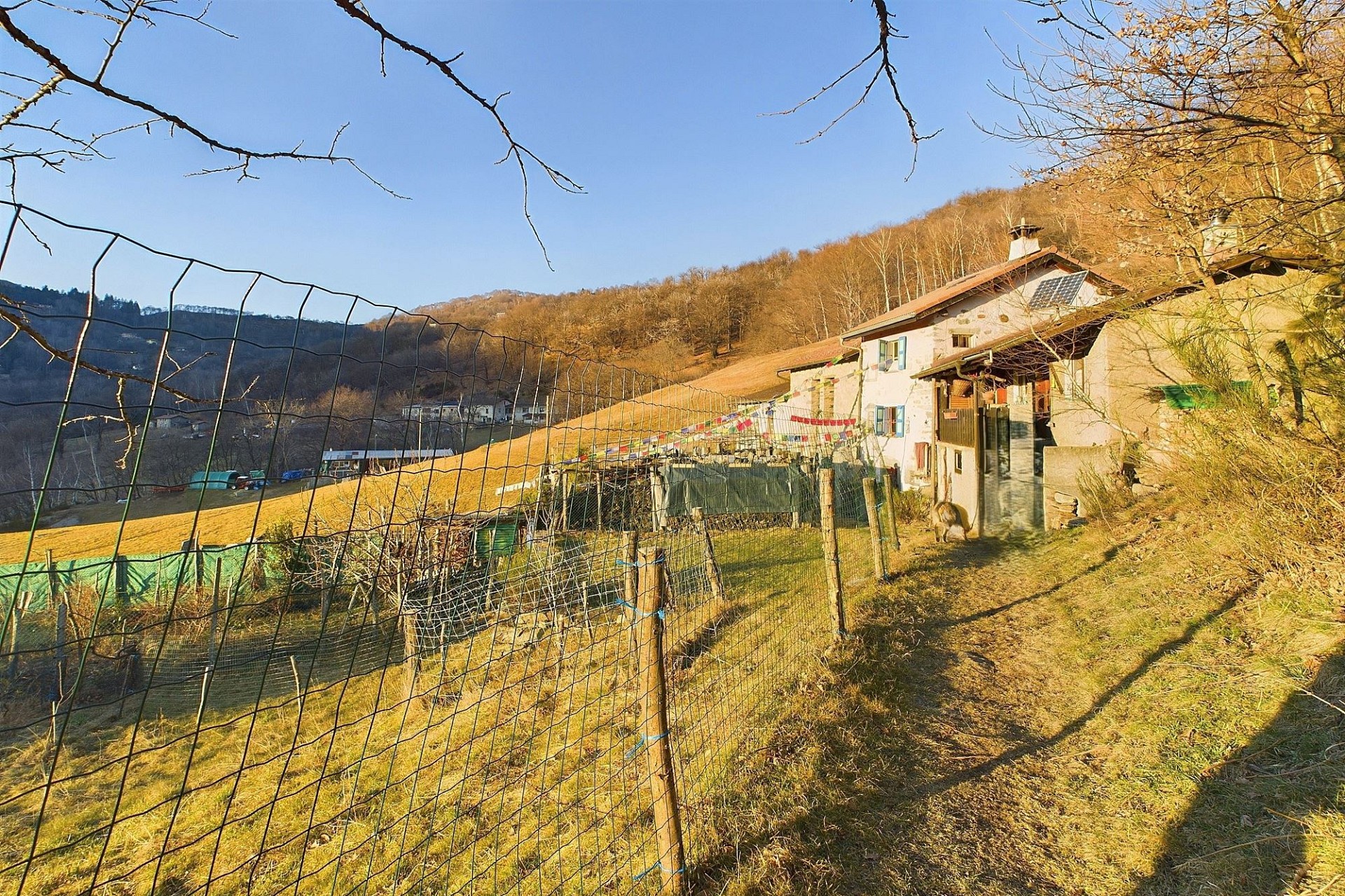 Ländliches Haus am Hang mit Zaun und Garten