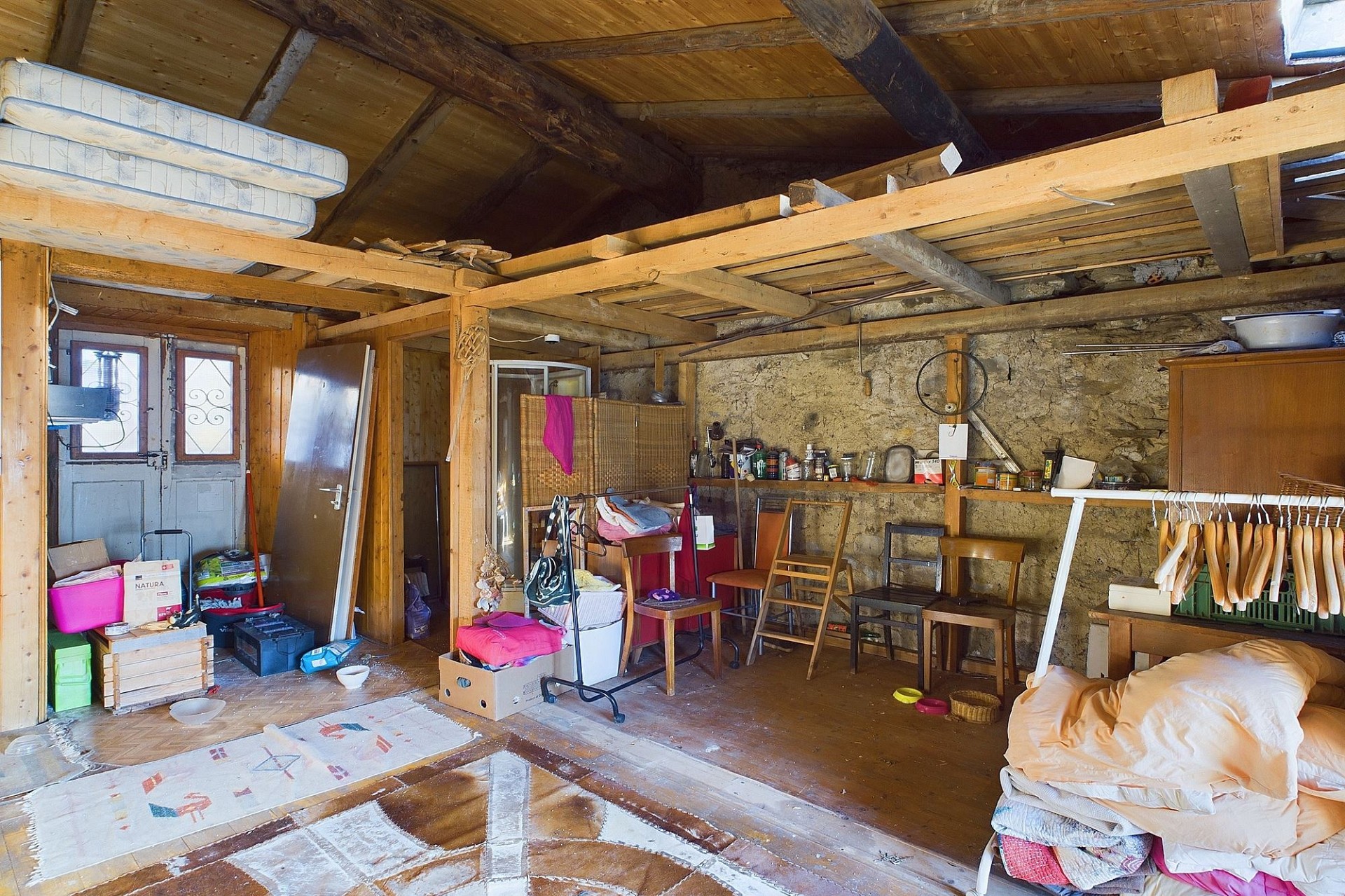 Rustikaler Dachboden-/Abstellraum mit sichtbaren Holzbalken