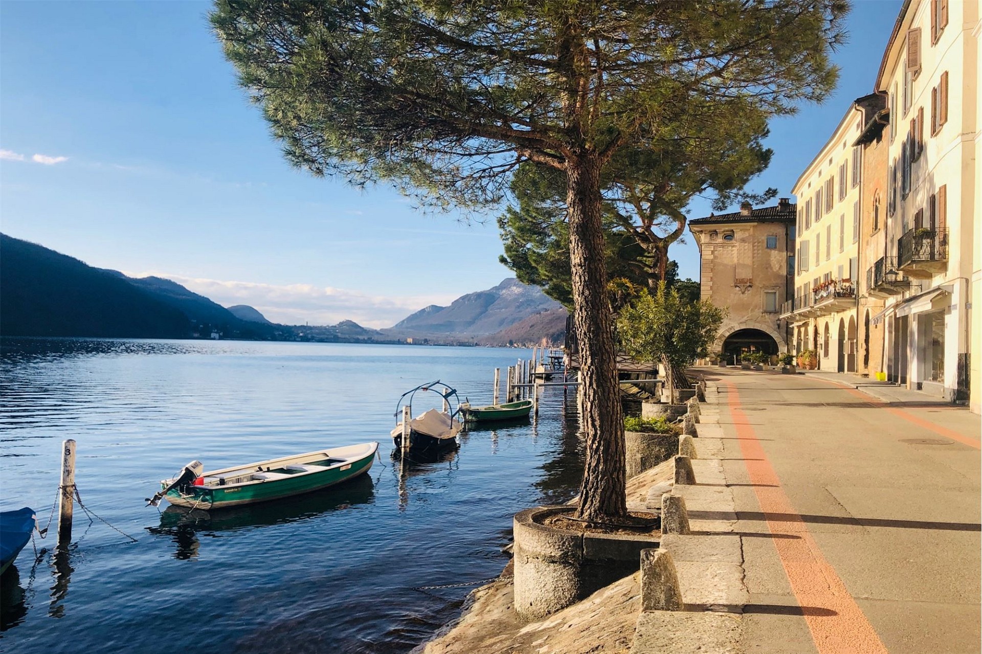 Seepromenade mit Booten und Bergblick
