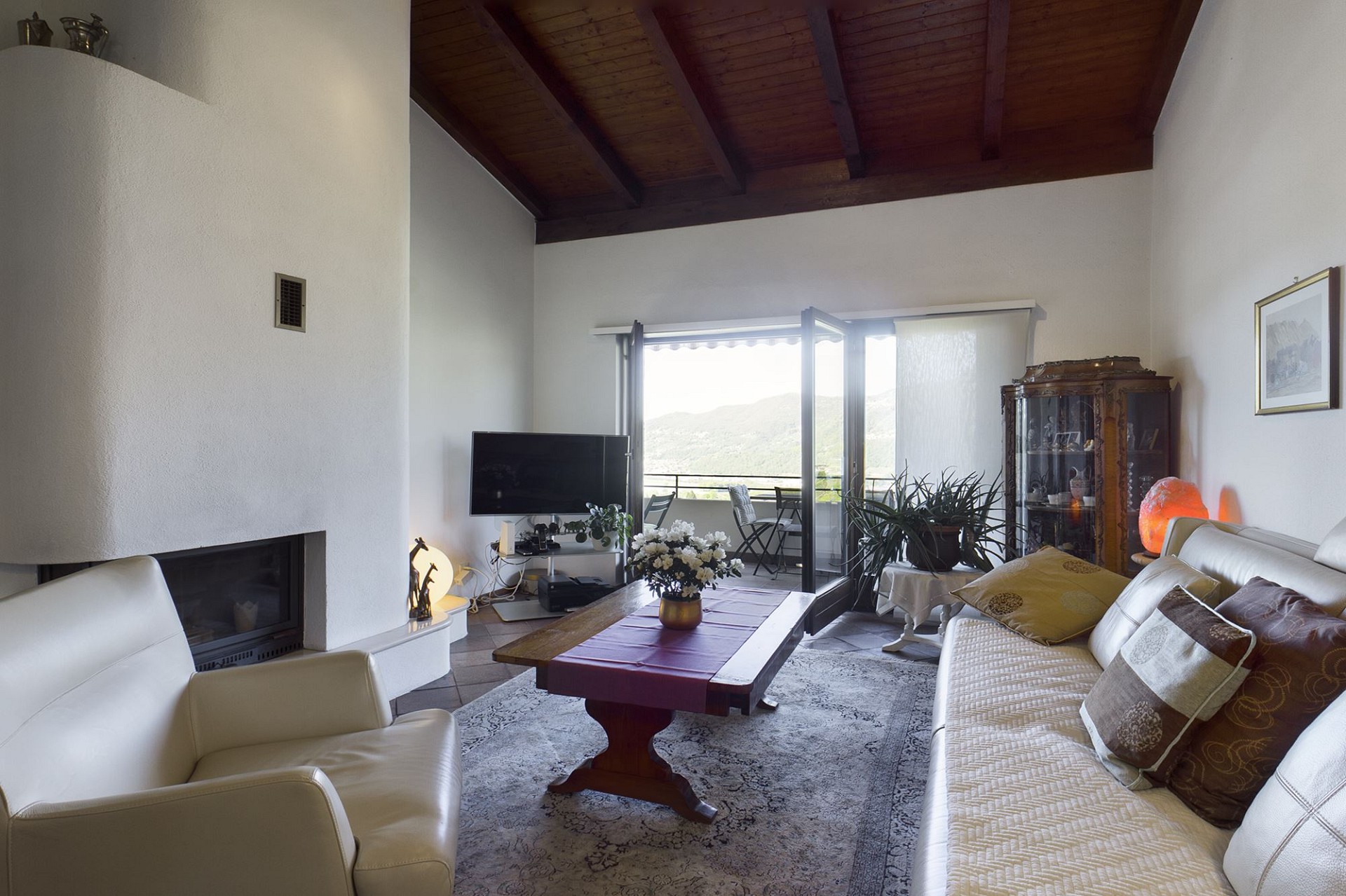 Wohnzimmer mit Kamin und Balkonblick