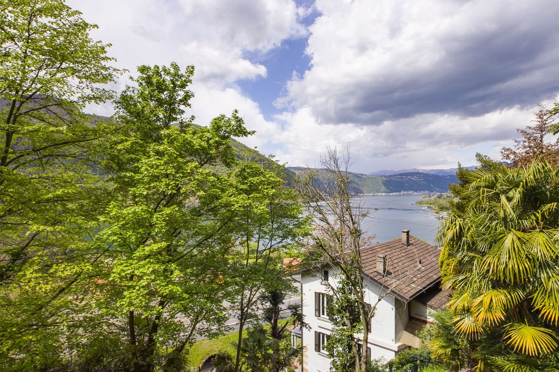 Seeblick über ein Haus im Grünen