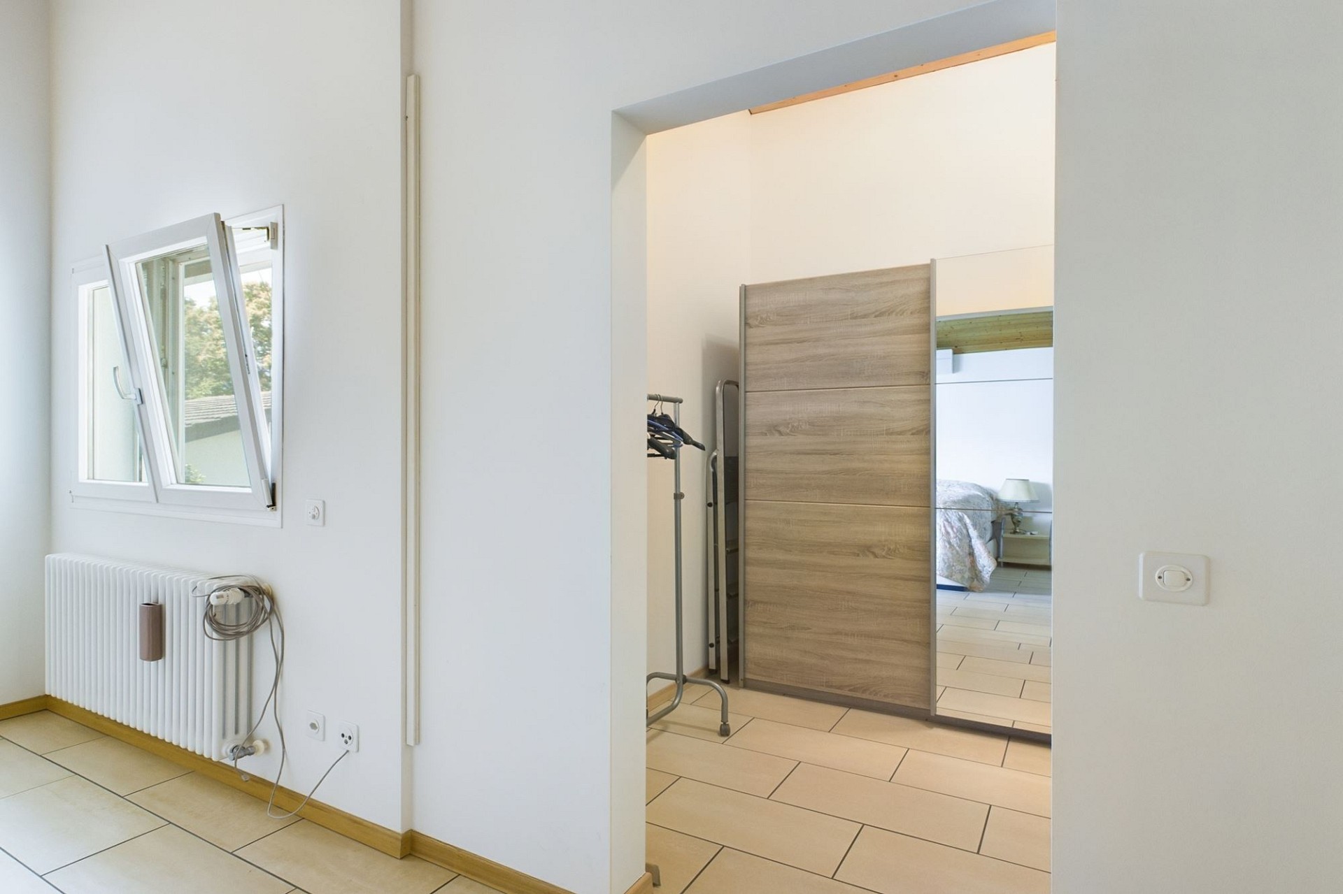 Helles Schlafzimmer mit Blick in einen zweiten Raum