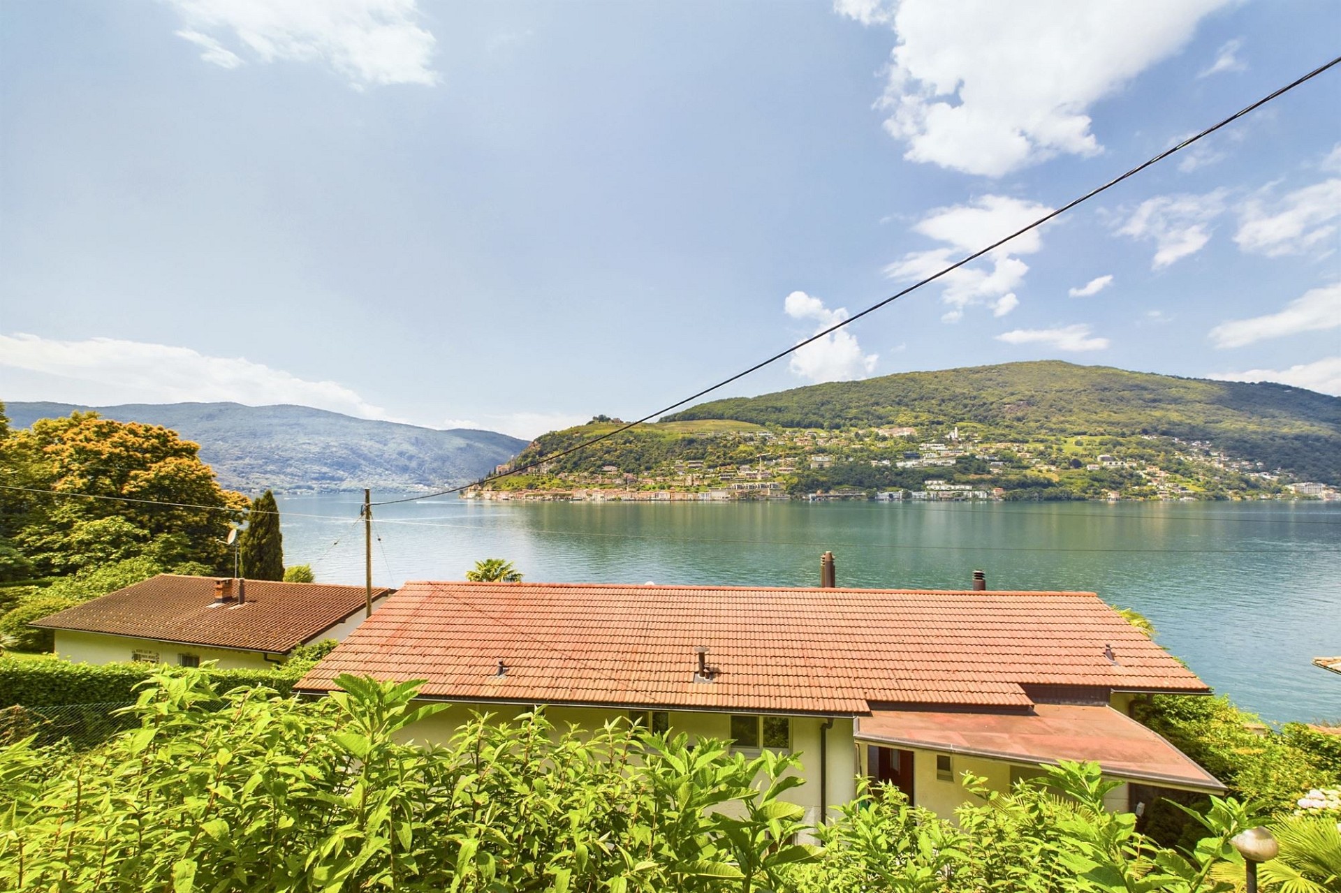 Seeblick über Häuser mit Ziegeldächern