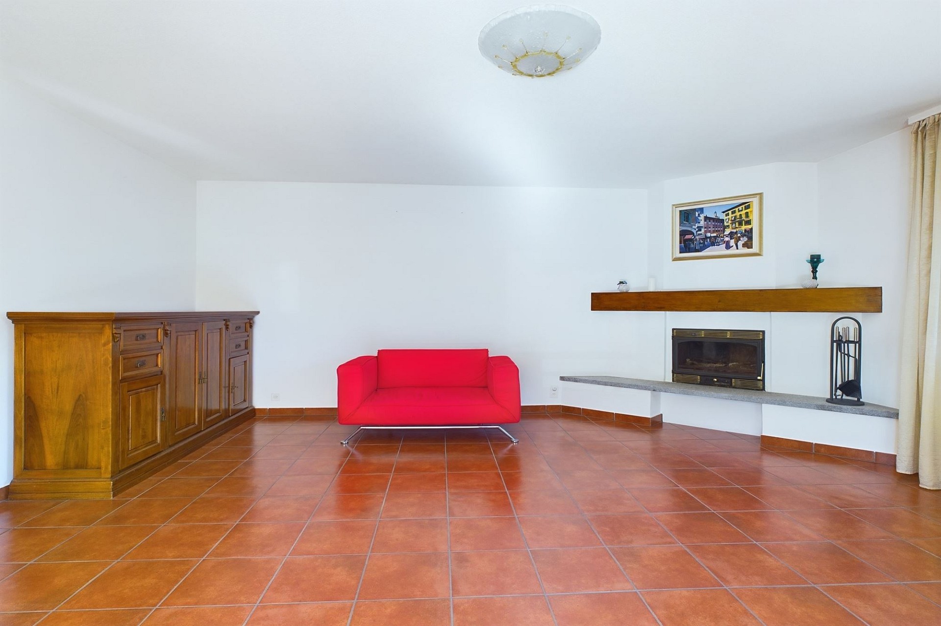 Wohnzimmer mit Kamin und Terrakottaboden