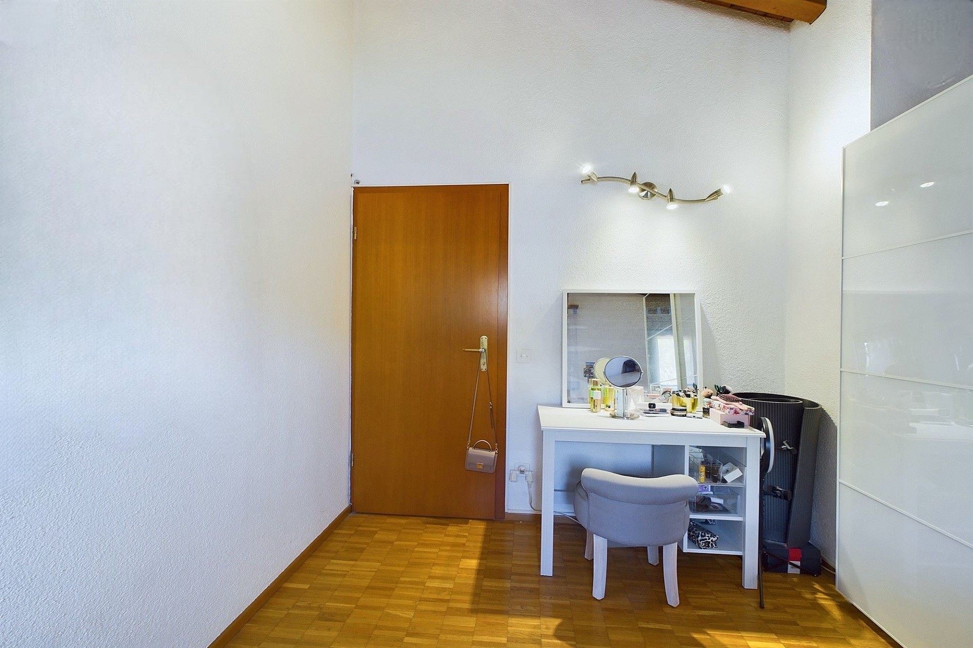 Heller Raum mit Arbeitsbereich und Holztür