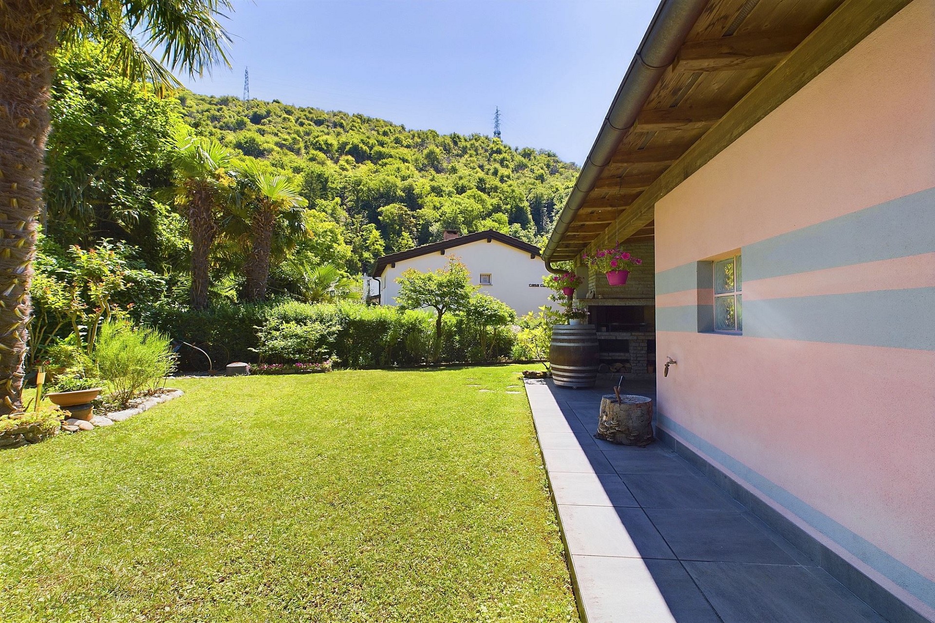 Garten mit Terrasse und Hausfassade