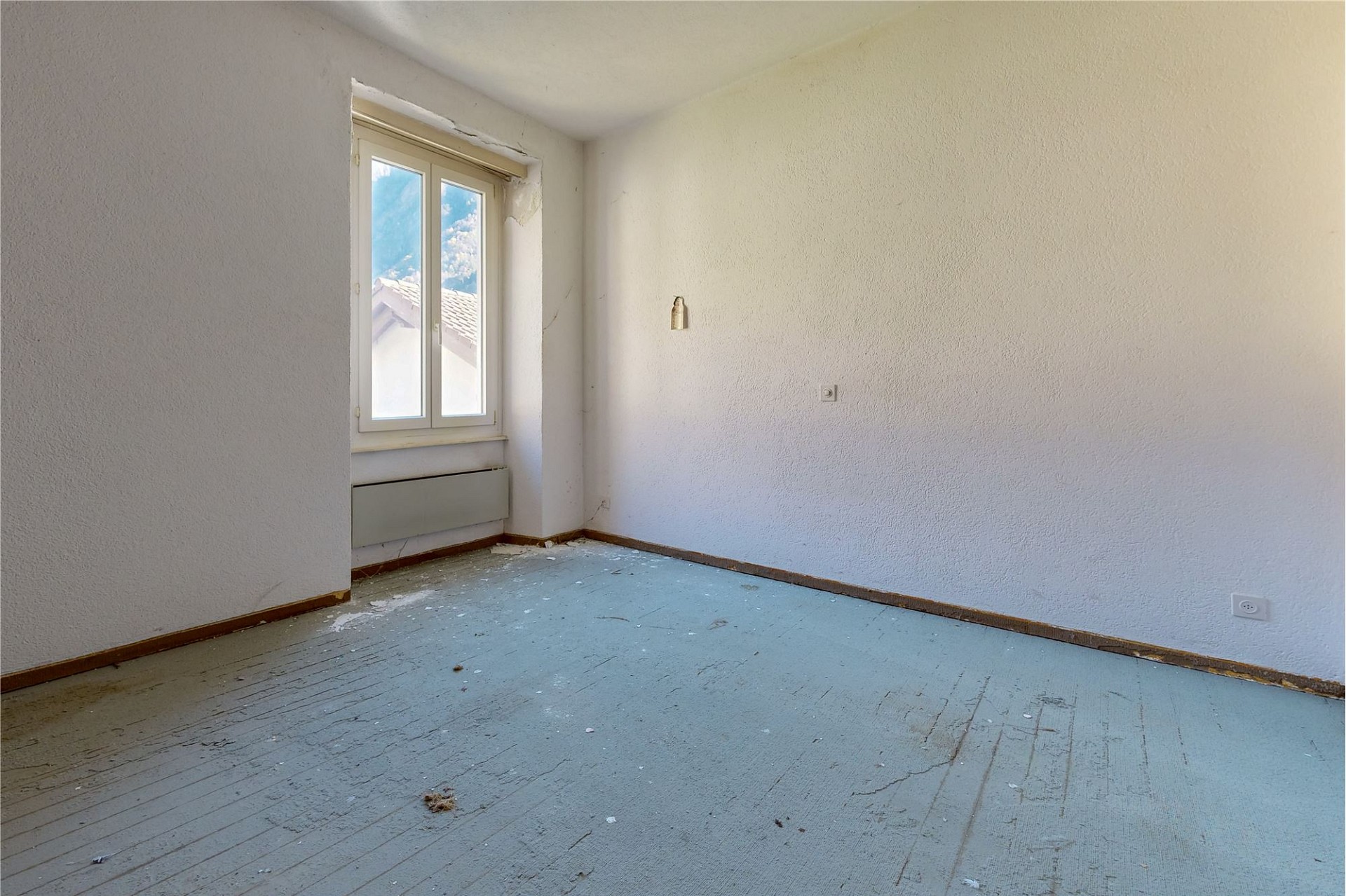 Leerer, renovierungsbedürftiger Raum mit Fenster