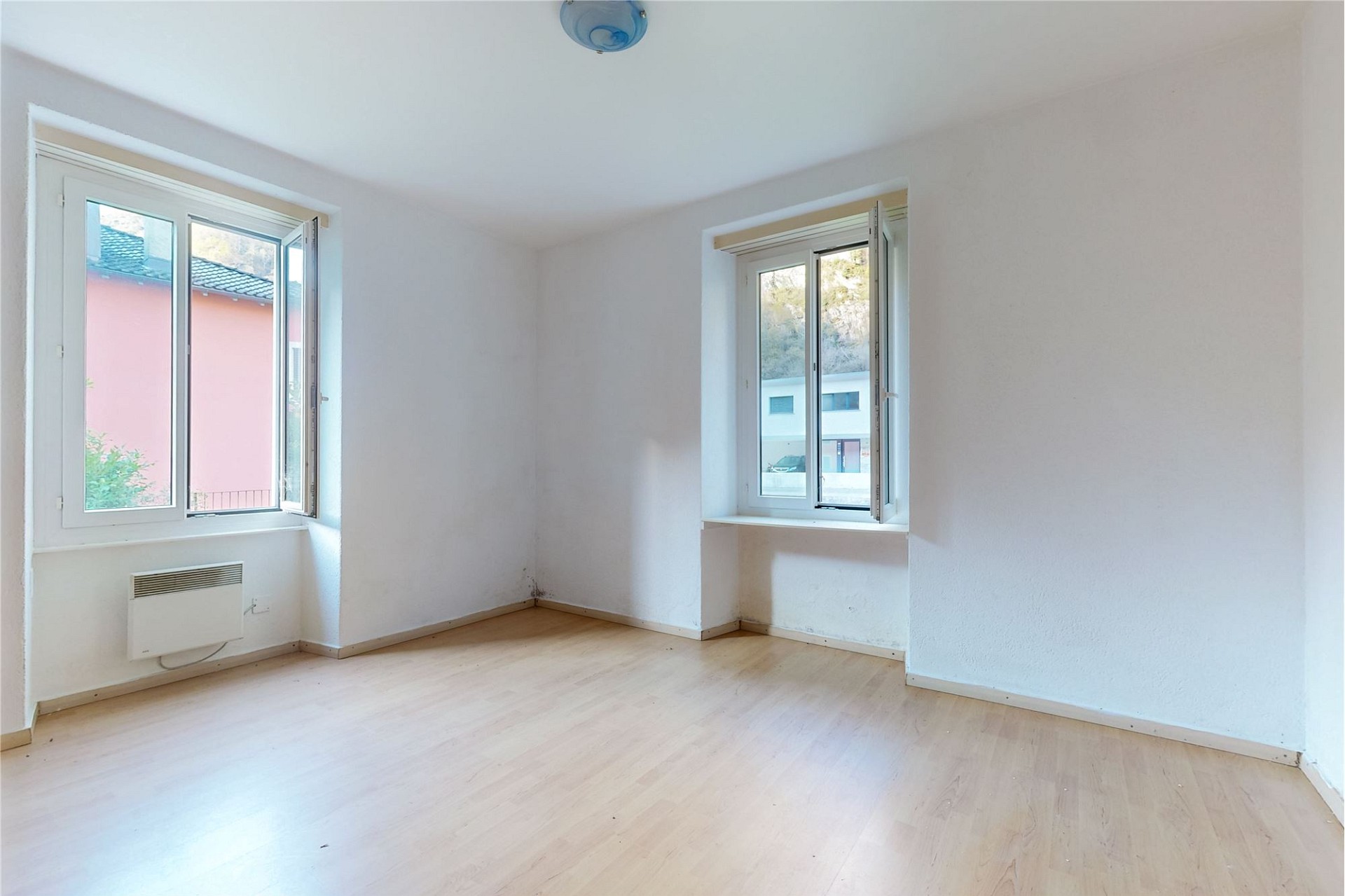 Helles, leeres Zimmer mit zwei Fenstern