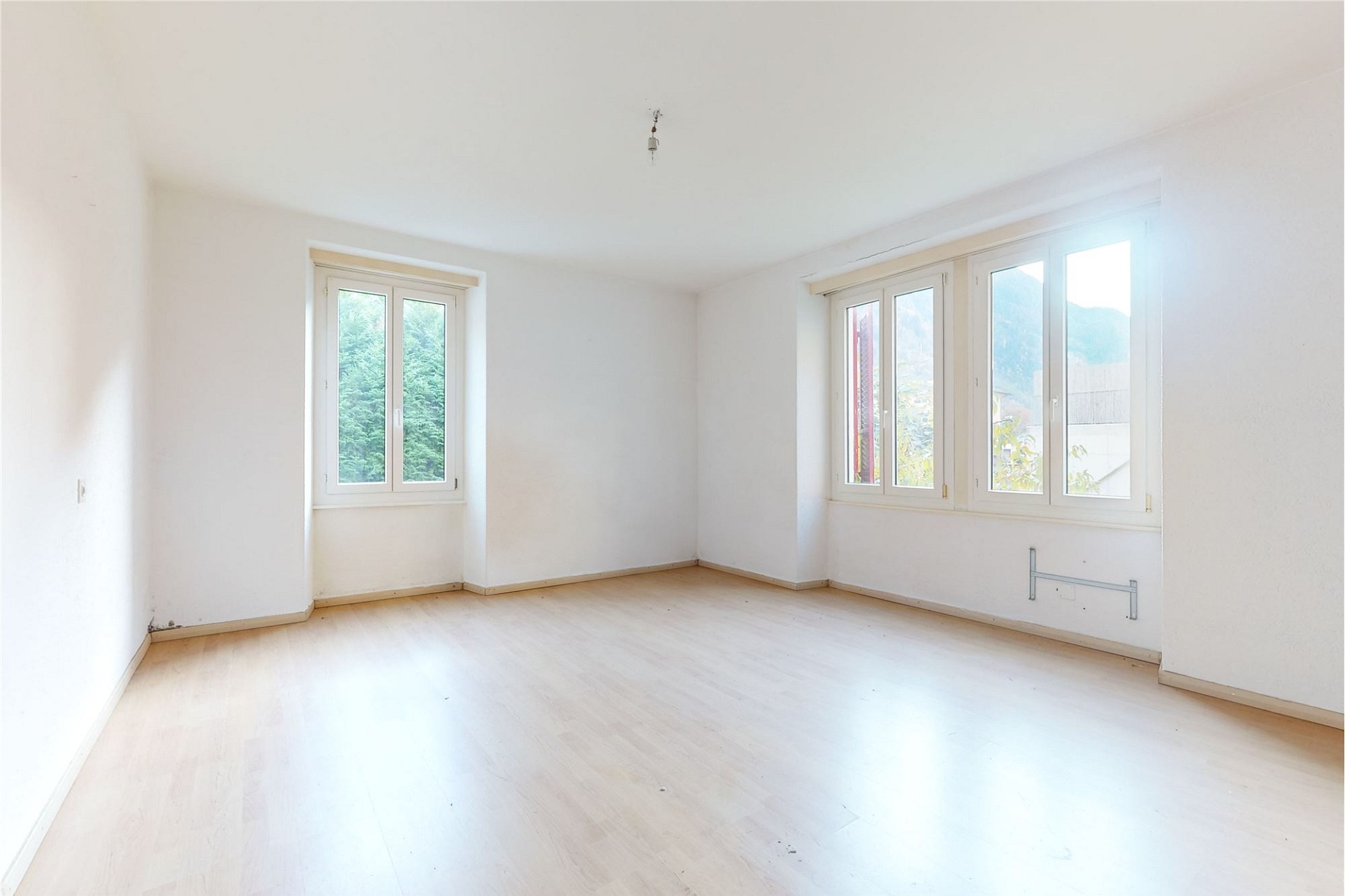Helles, leerstehendes Zimmer mit großen Fenstern