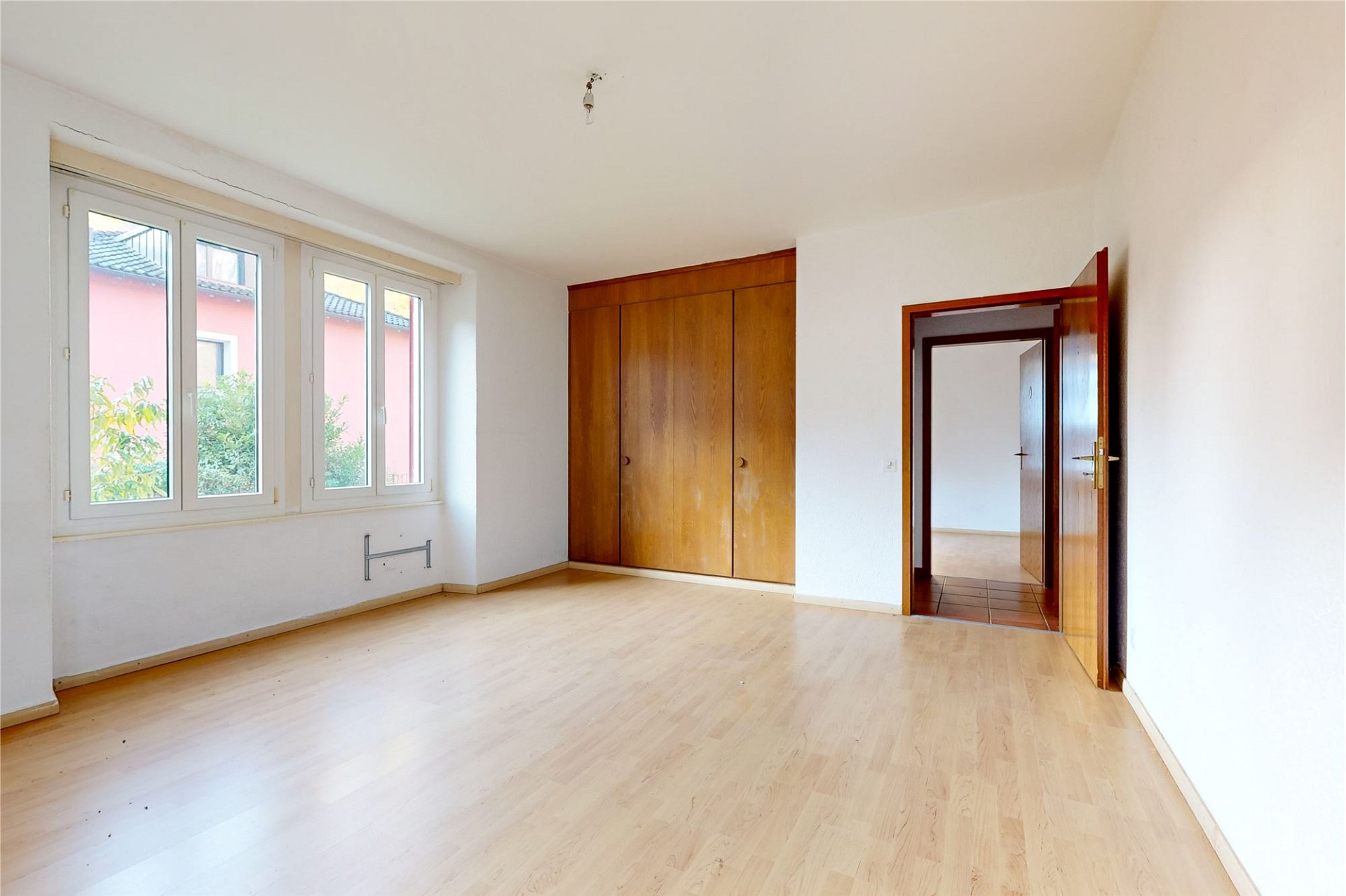 Leeres Schlafzimmer mit Einbauschrank und großen Fenstern
