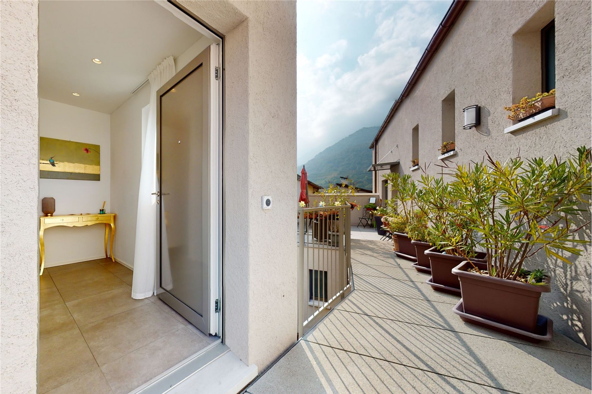Terrasse mit offenem Eingangsbereich und Blick in die Berge