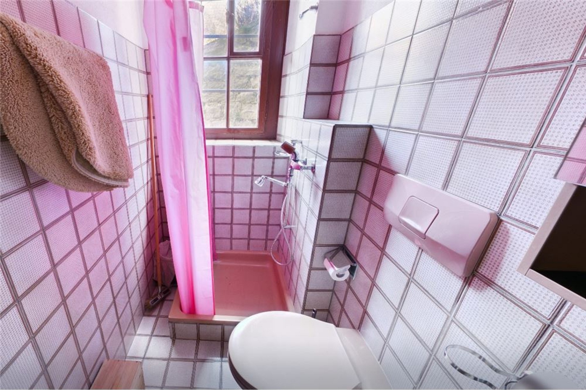 Kleine rosa geflieste Dusche mit Fenster