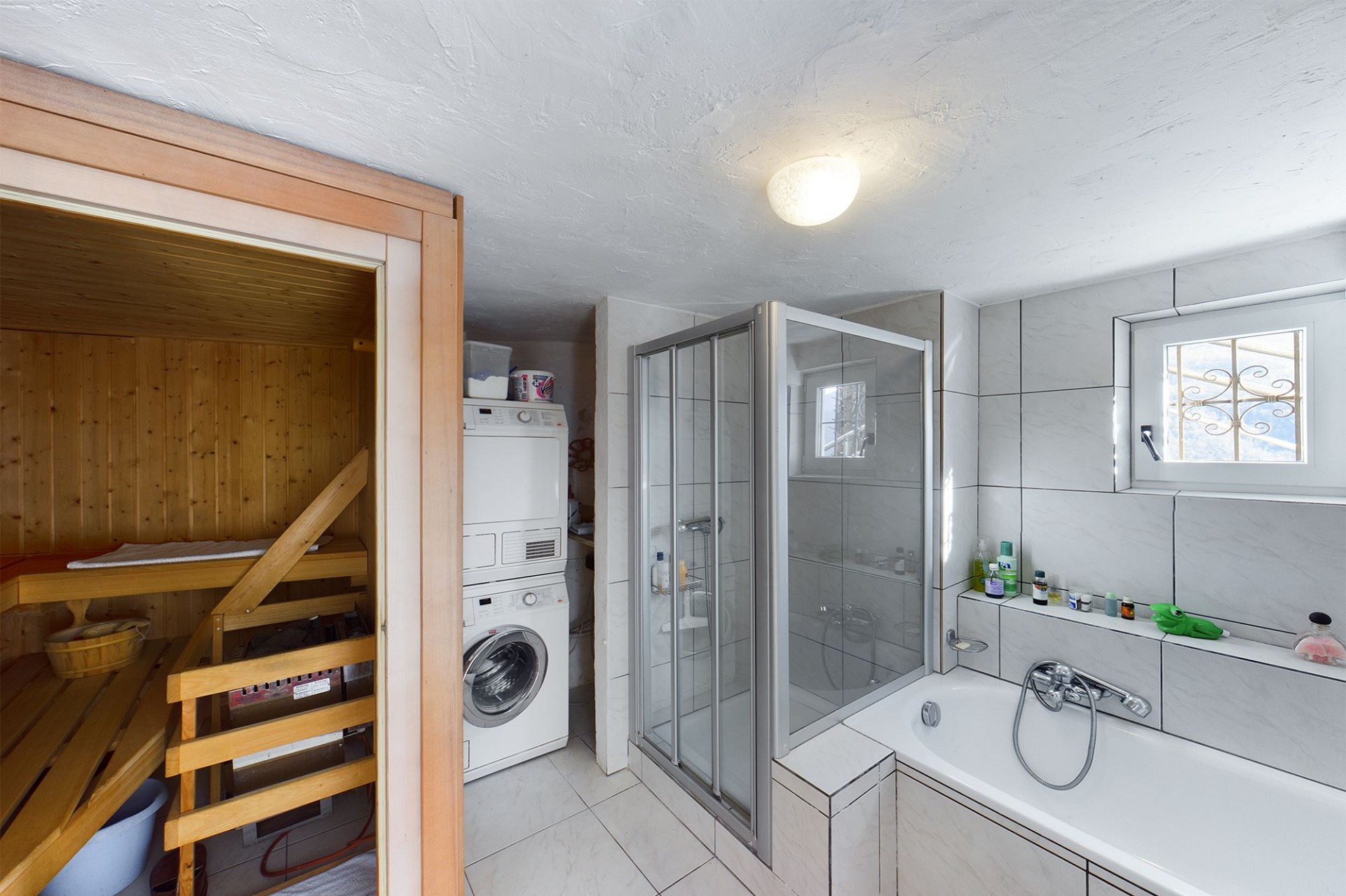 Badezimmer mit Sauna-Nische und Waschmaschinenbereich