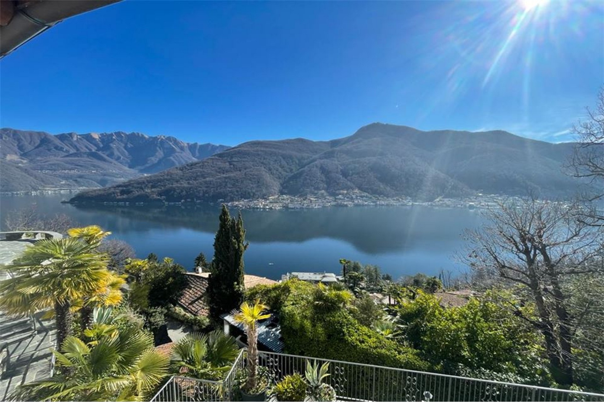 Seenblick mit Bergen und Garten