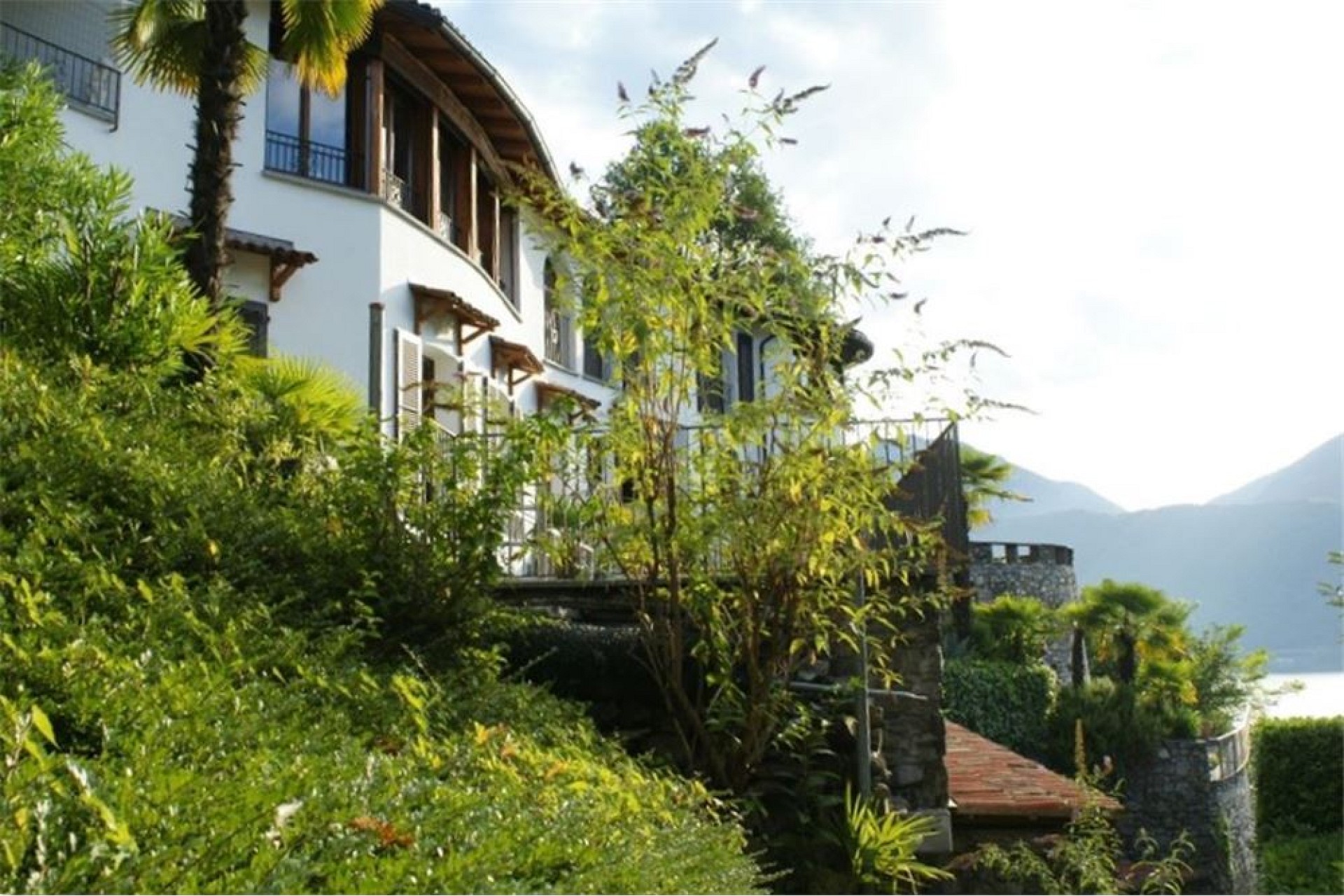 Außenansicht eines mediterran wirkenden Hauses mit Garten und Bergblick