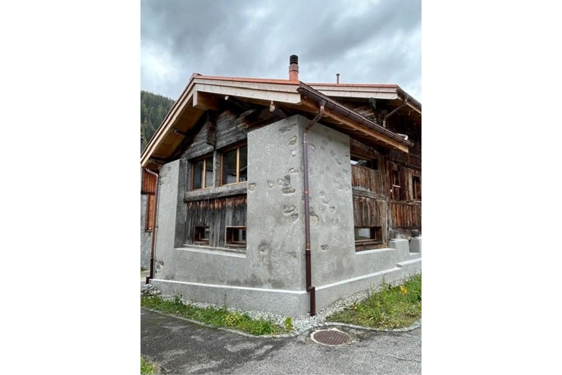 Alpenhaus mit verputzter Fassade und Holzverkleidung
