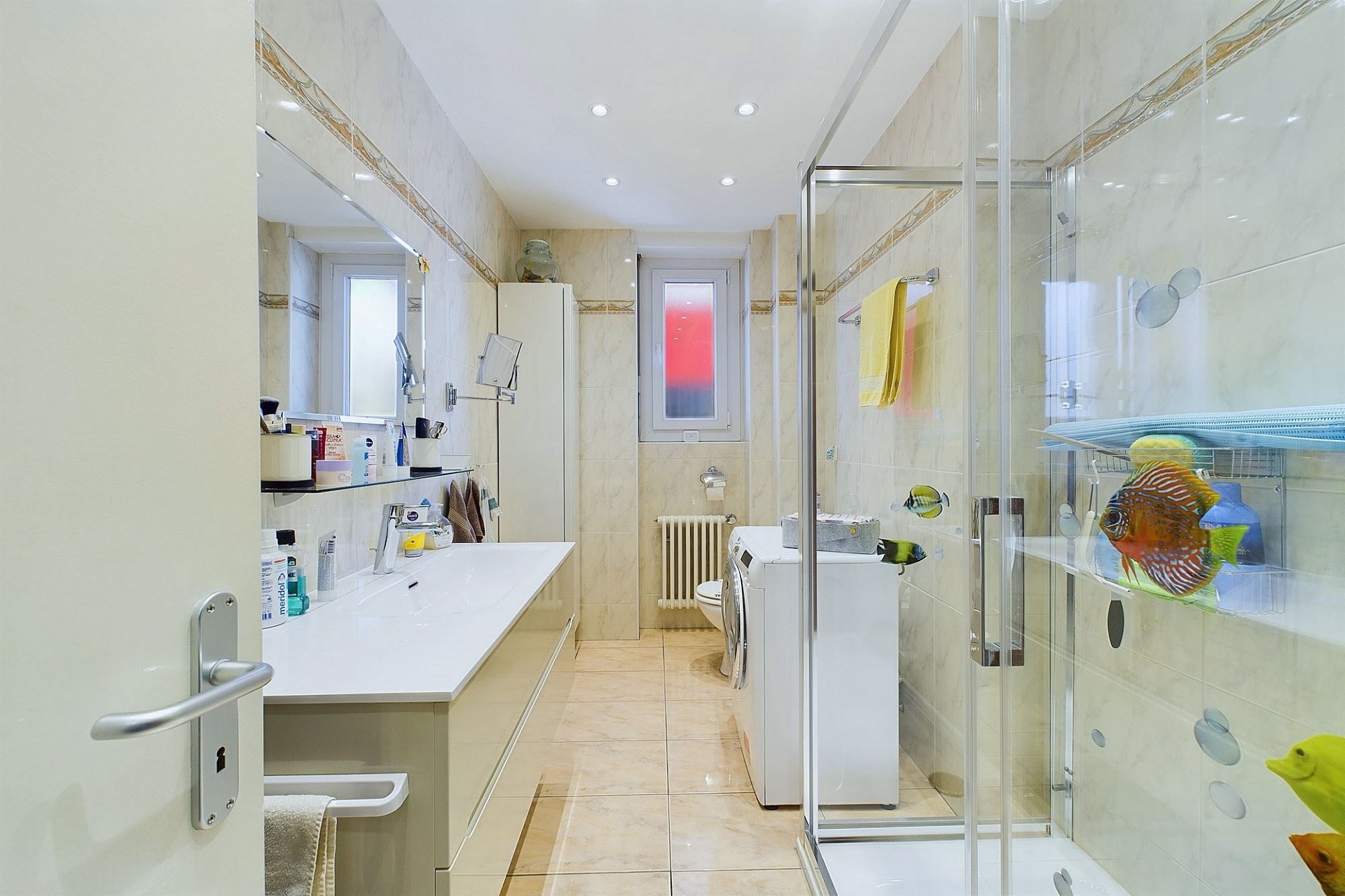 Helles, schmales Badezimmer mit Dusche und Waschmaschine