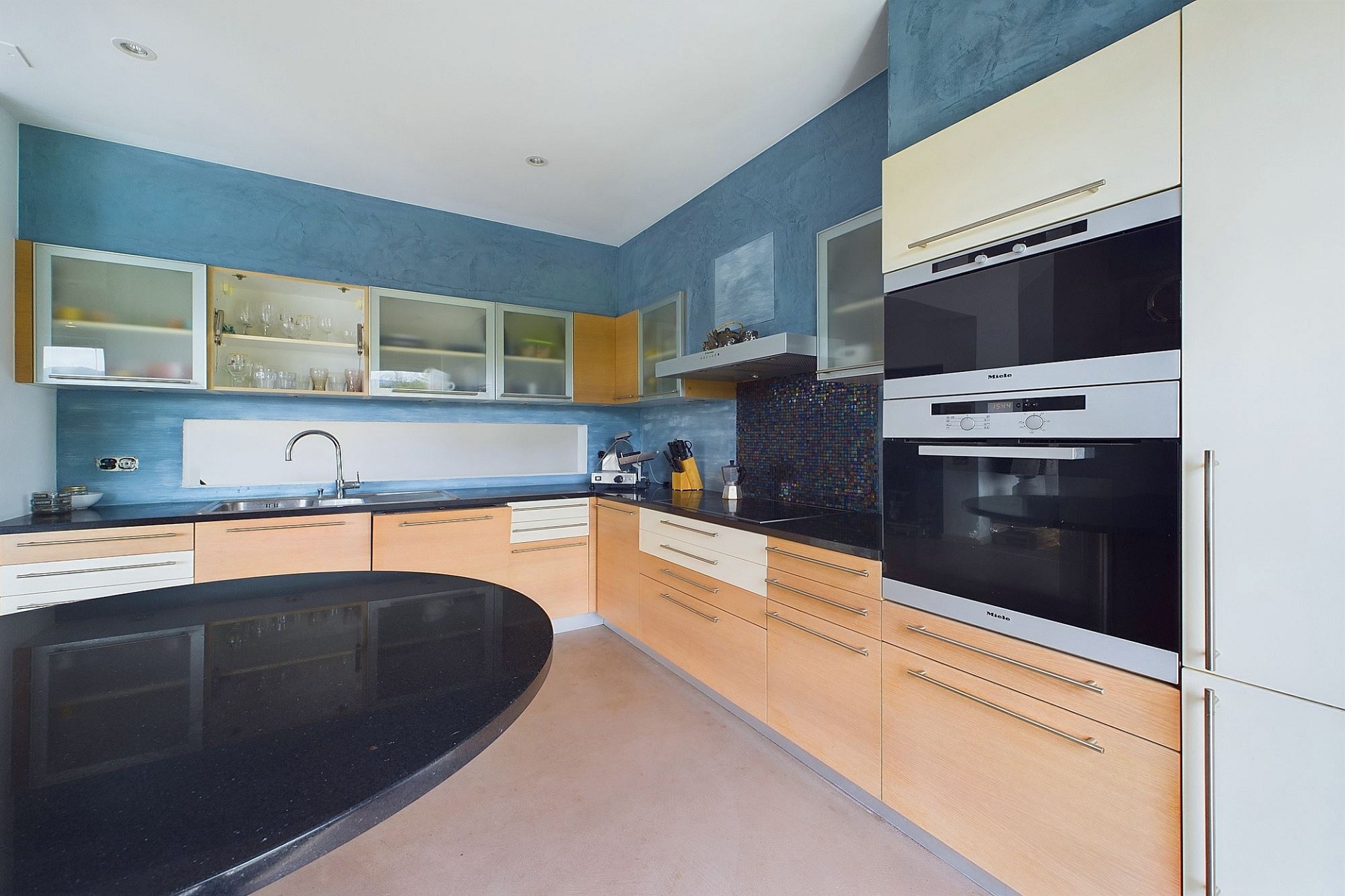 Moderne Küche mit blauer Wand und Holzfronten