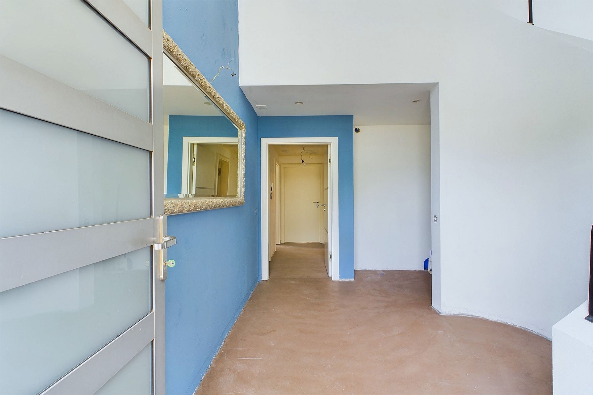 Moderner Eingangsbereich mit blau-weißen Wänden und frosted Glastür