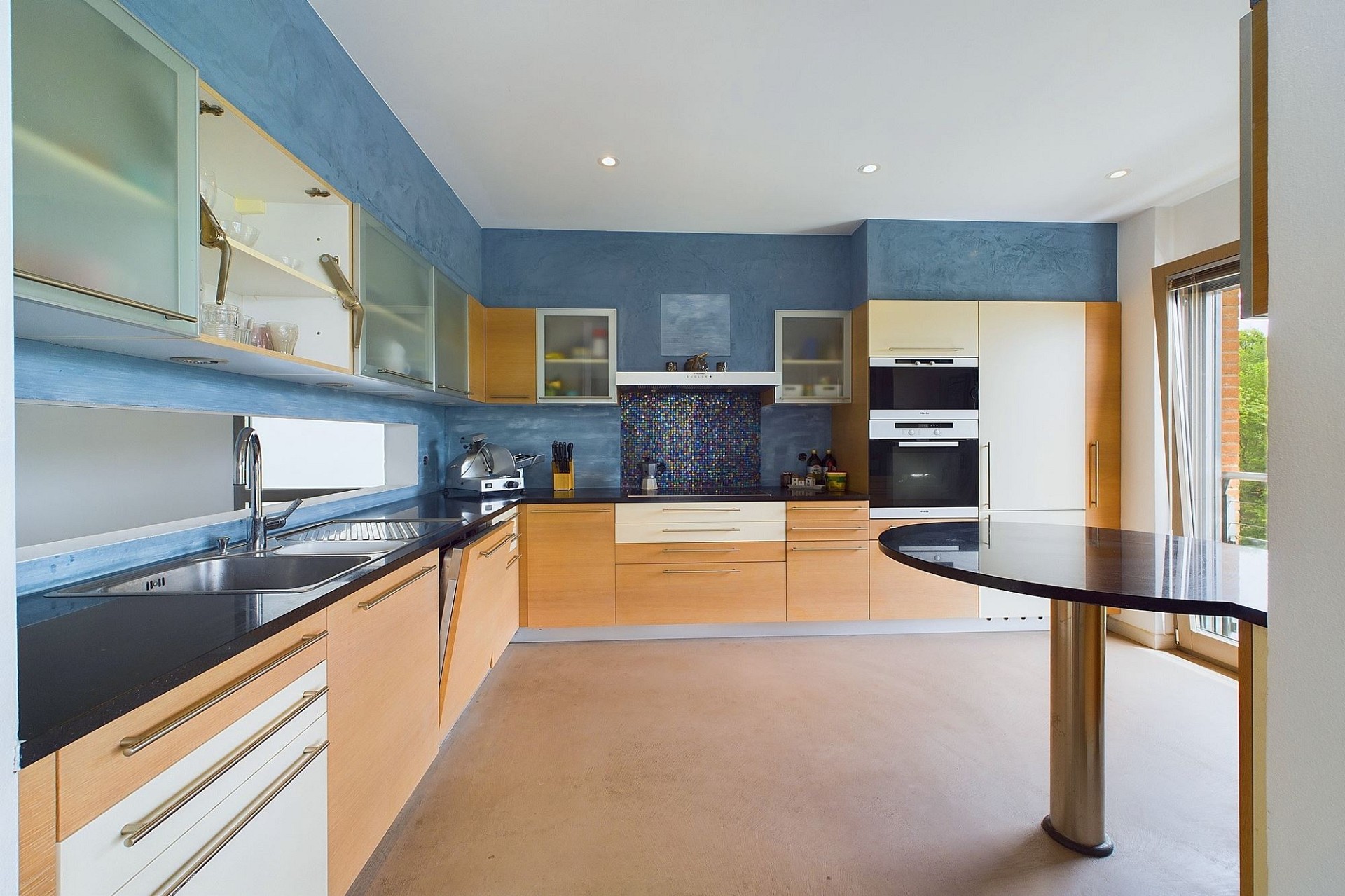 Moderne Küche mit blauen Wänden und Holzfronten