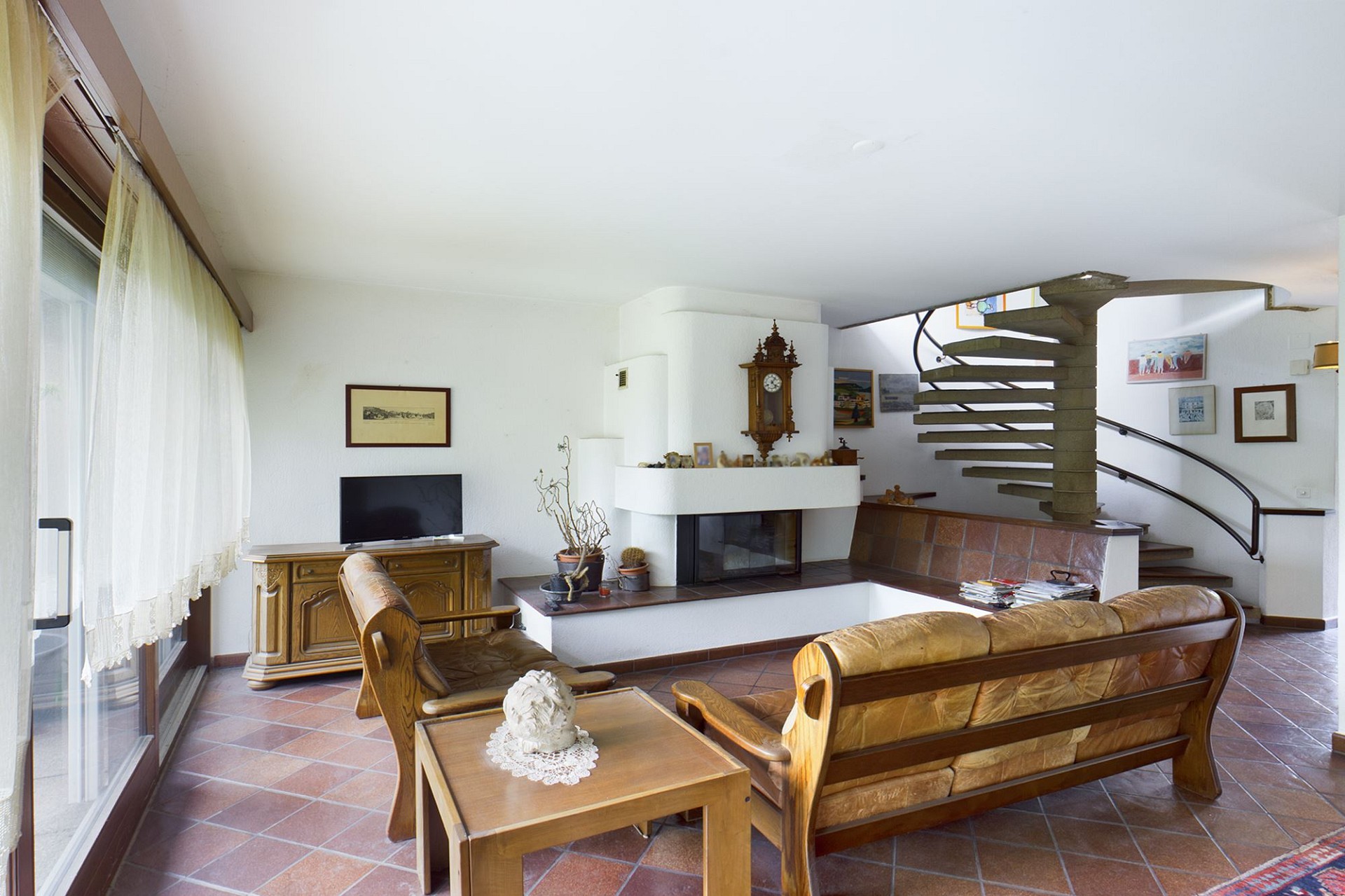 Wohnzimmer mit Kamin und Wendeltreppe