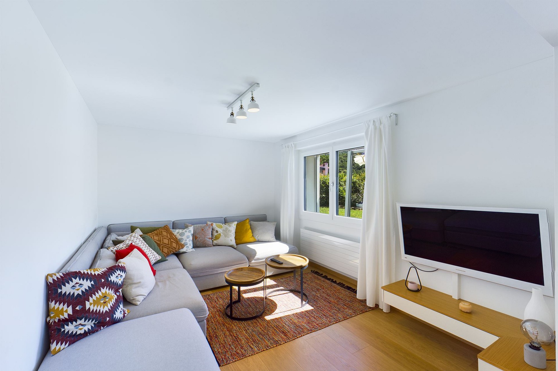 Helles Wohnzimmer mit L‑Sofa und TV