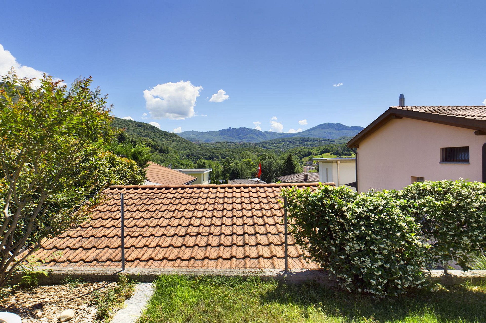 Bergblick über Ziegeldächer und Garten