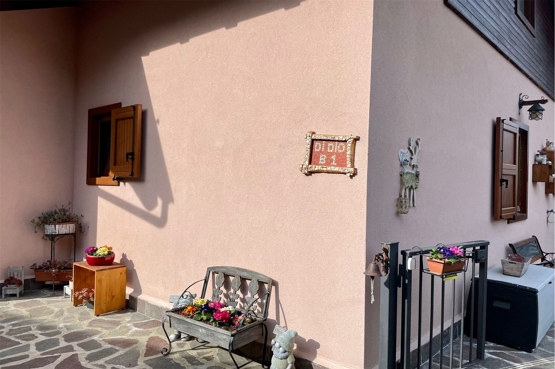 Außenbereich mit rosa Putzfassade und Terrasse