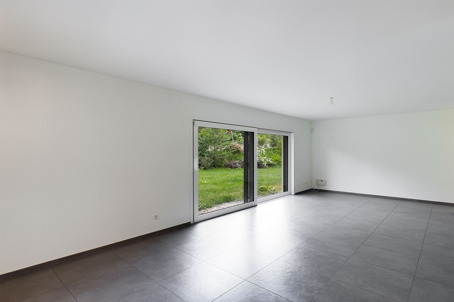 Heller leerer Wohnraum mit Terrassentür