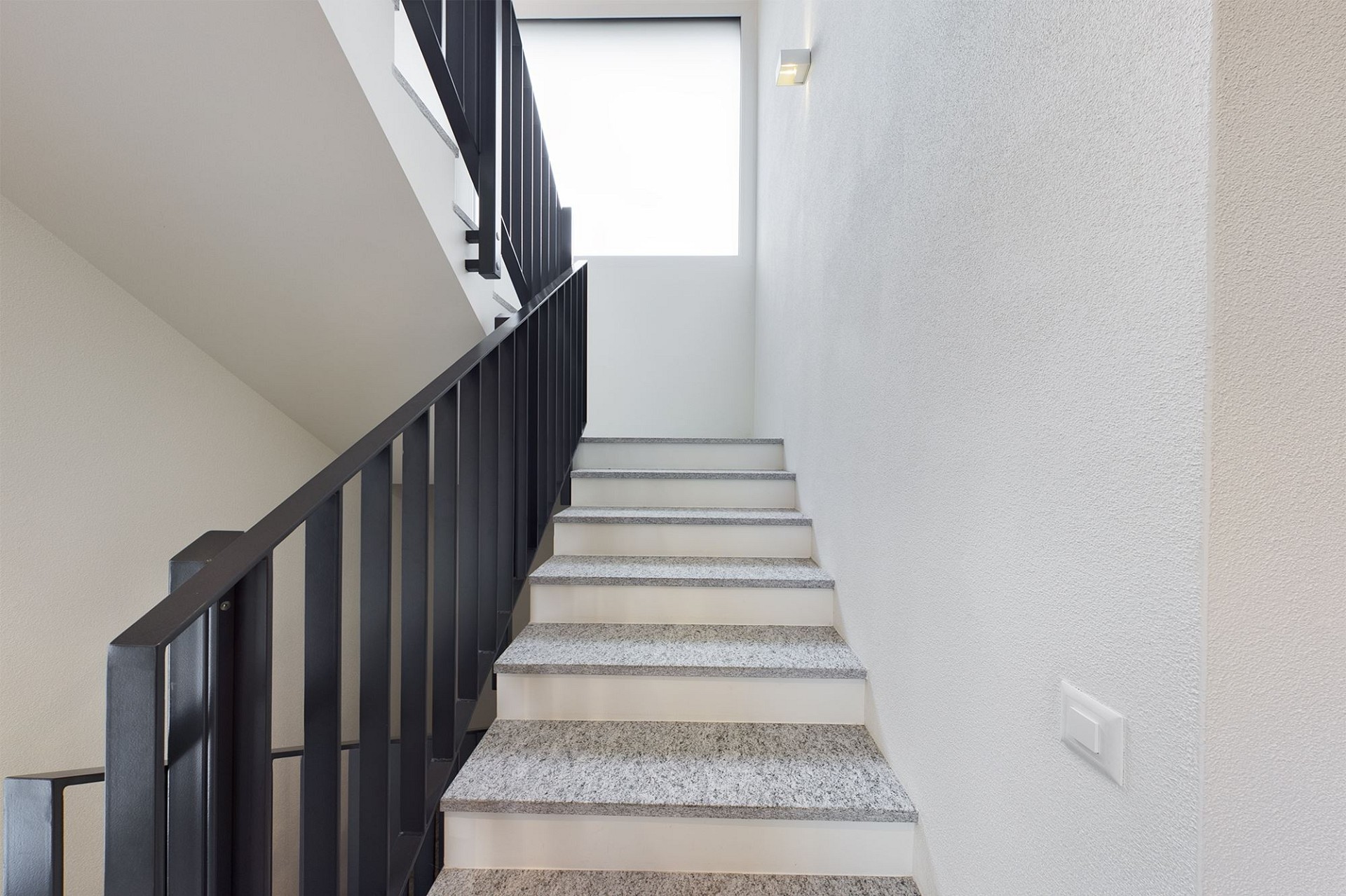 Treppenhaus mit schwarzem Geländer