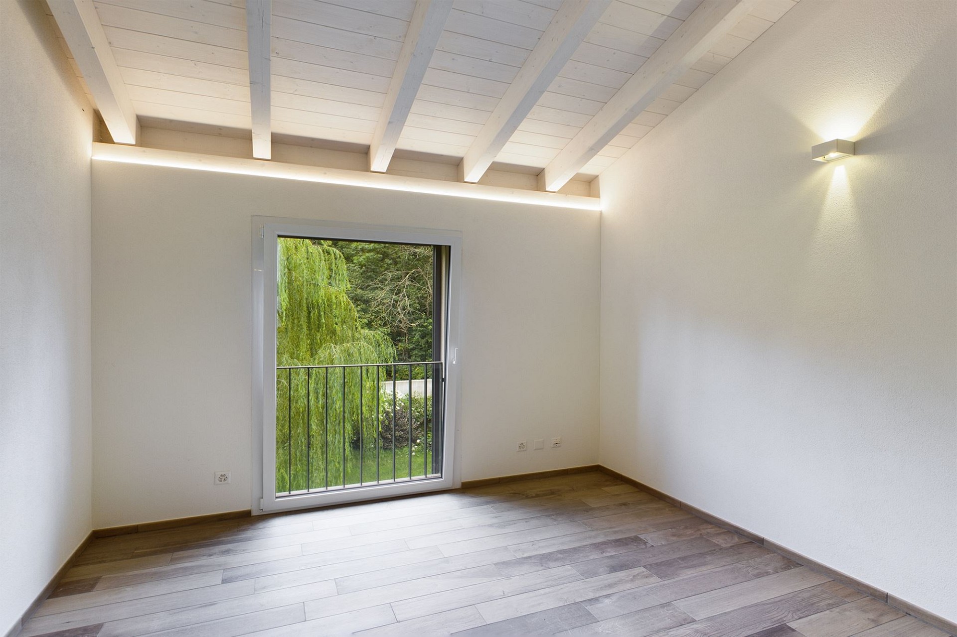 Helles, leeres Zimmer mit Balkon- bzw. Terrassentür