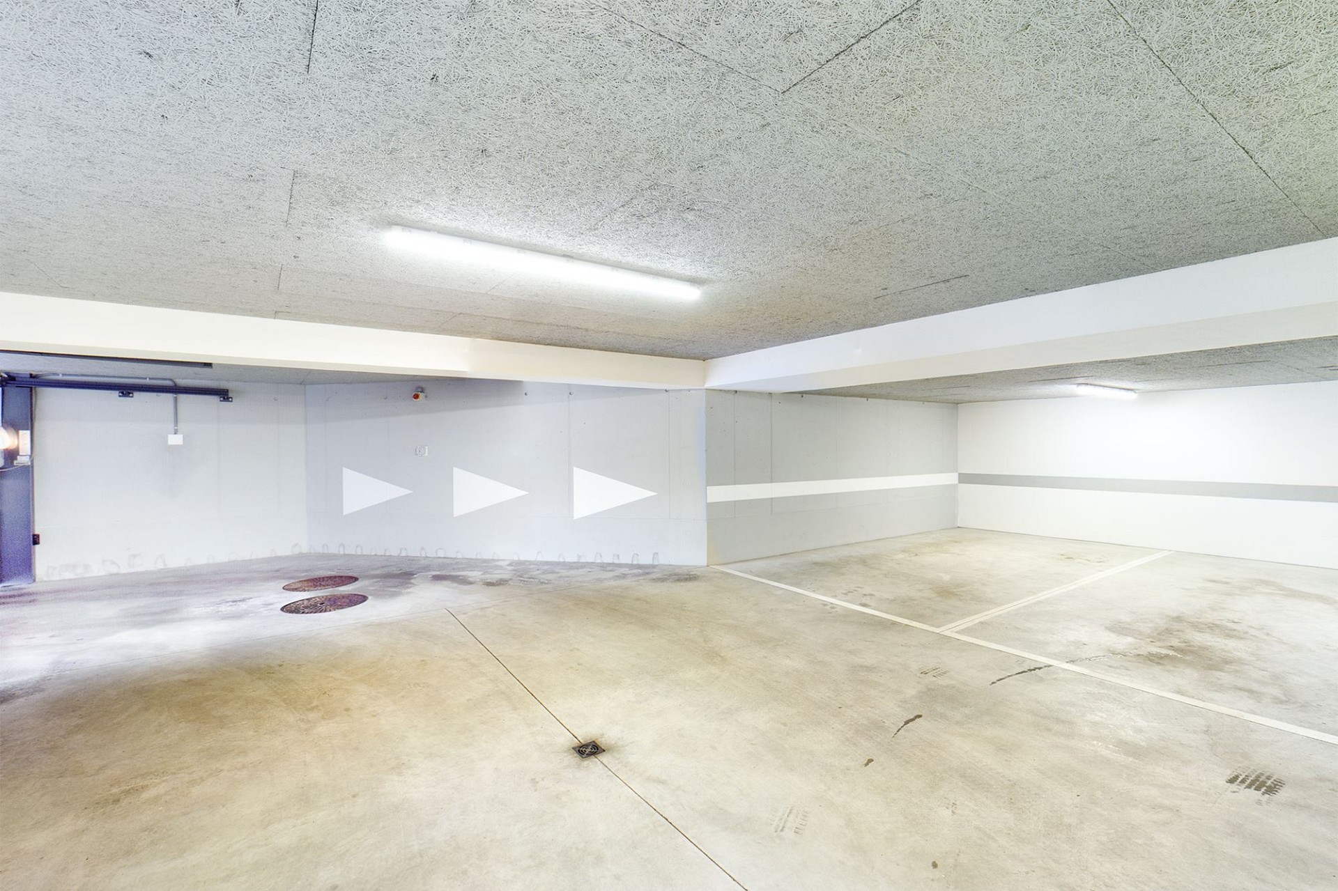 Tiefgarage mit Betonboden und Deckenbeleuchtung