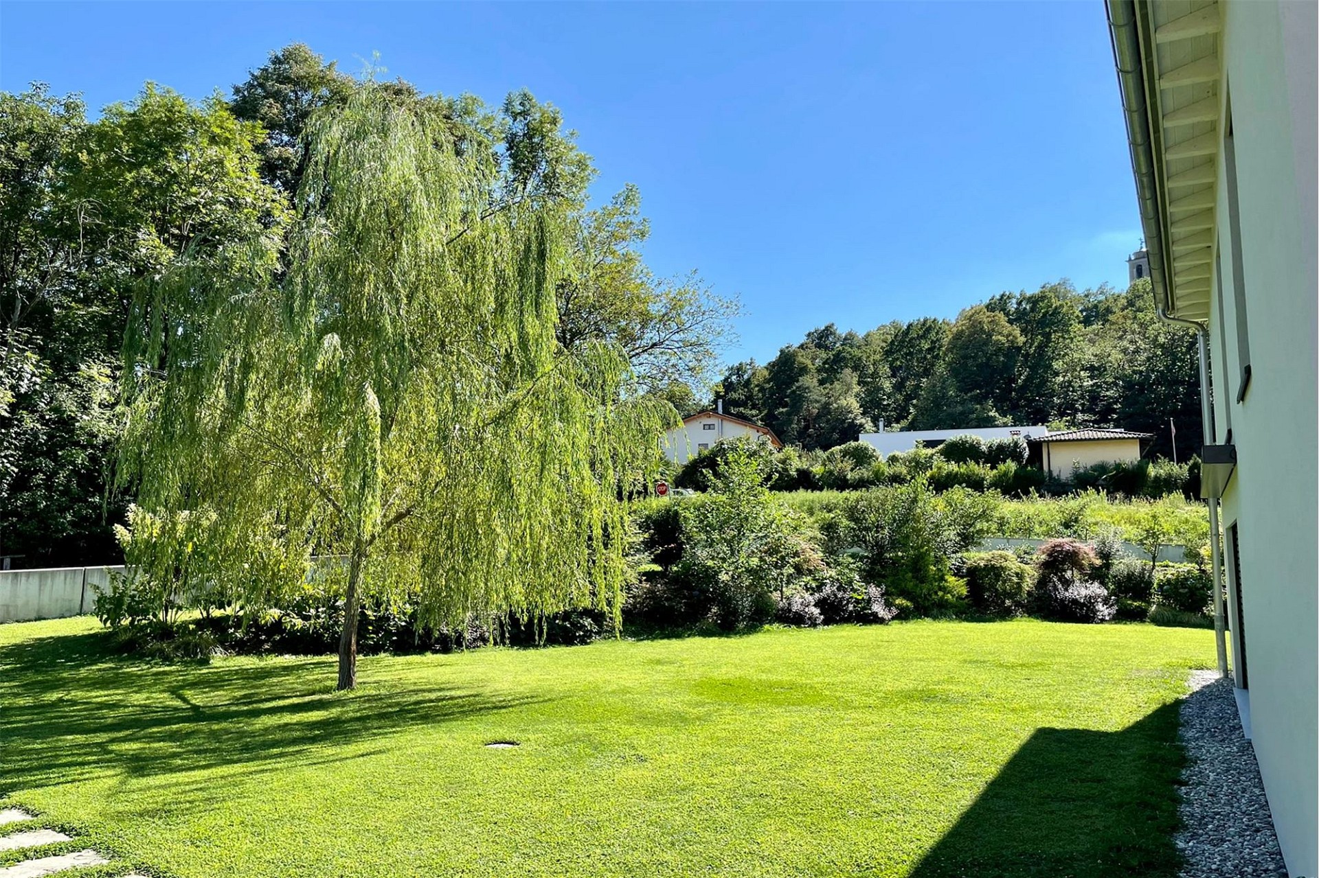 Großer gepflegter Garten mit Rasen und Baum