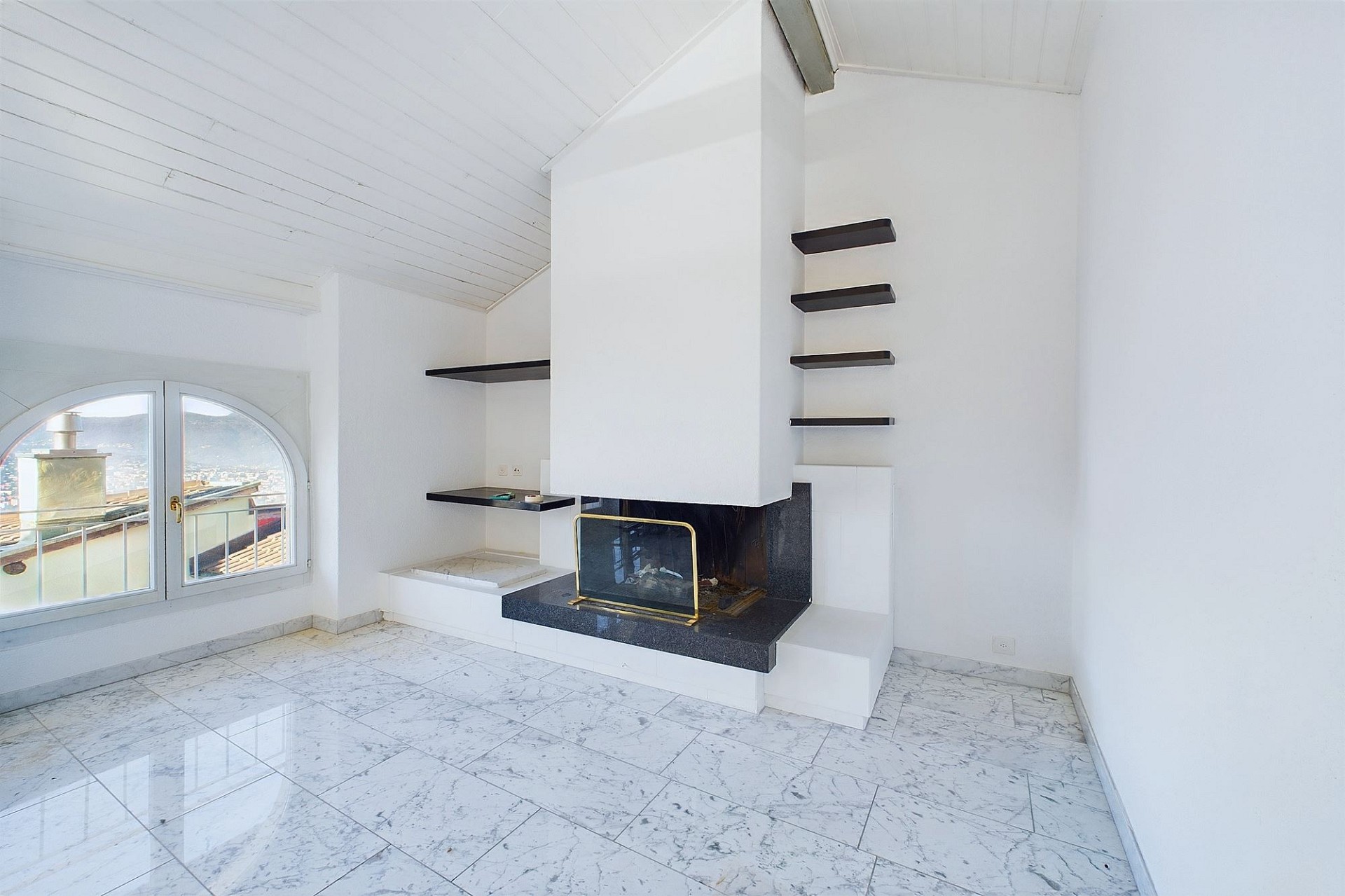 Heller Wohnraum mit Kamin und Balkonblick
