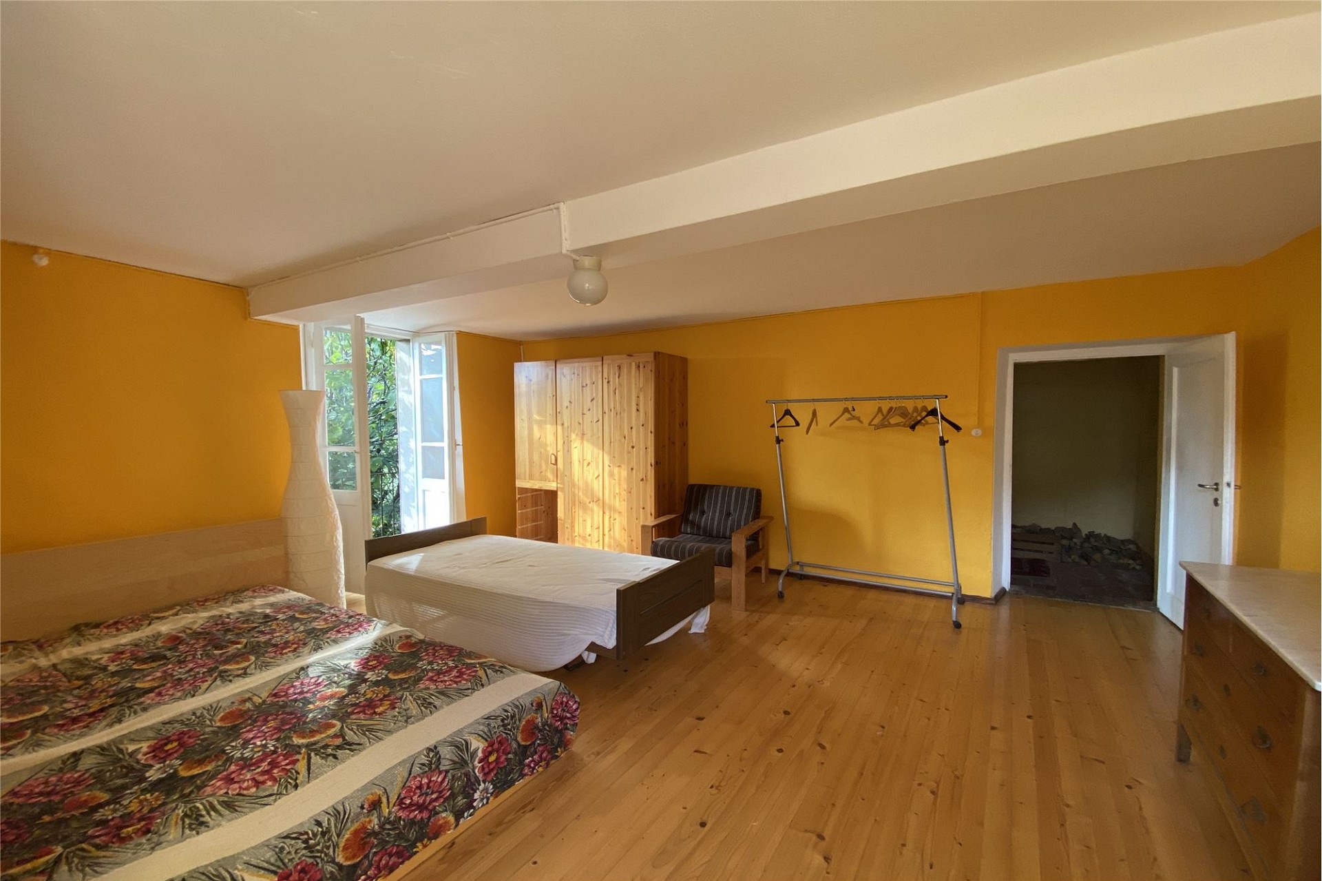 Schlafzimmer mit zwei Betten und gelben Wänden