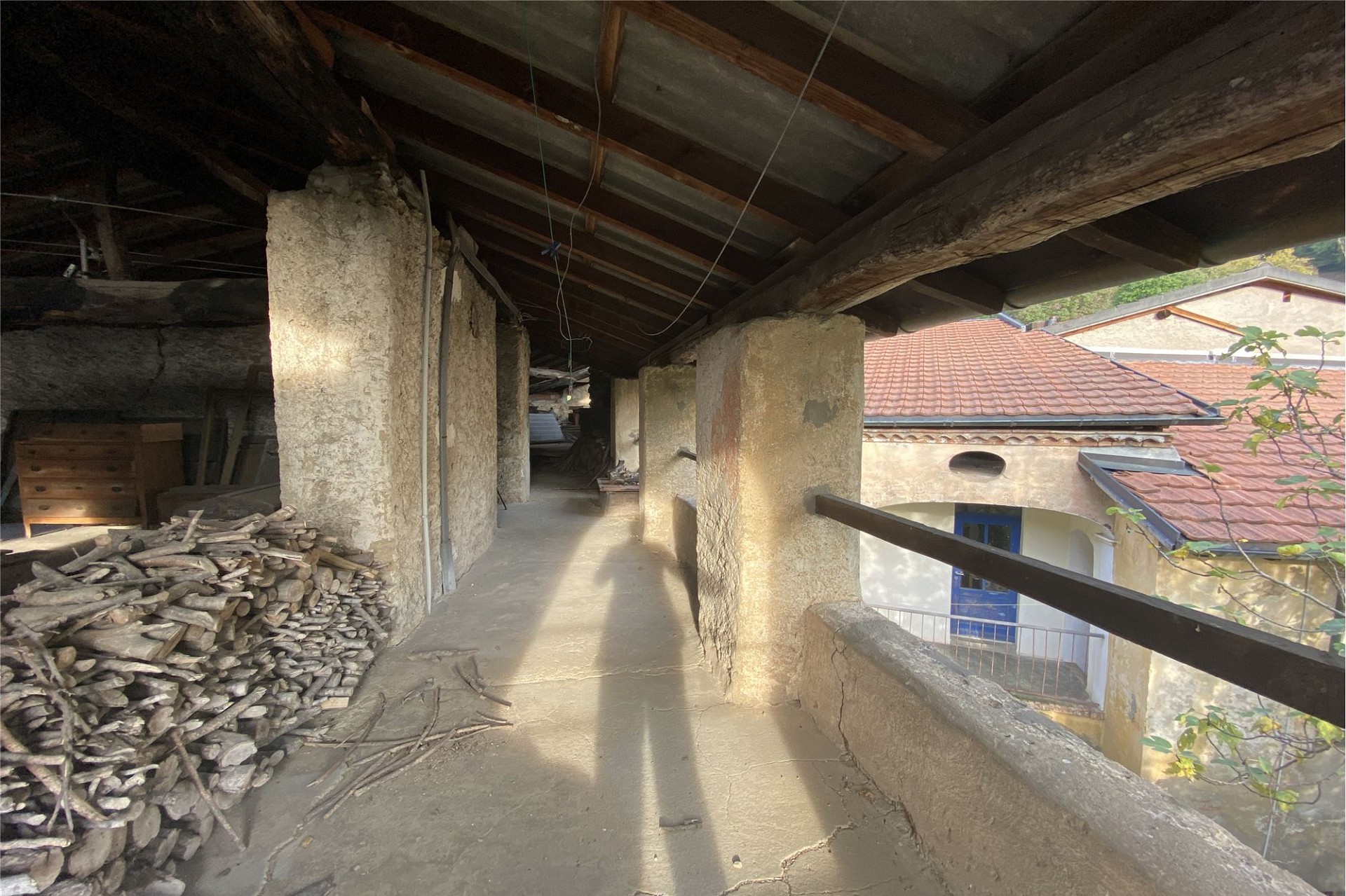 Überdachter Außenkorridor mit Holzbalken und Blick auf das Dach