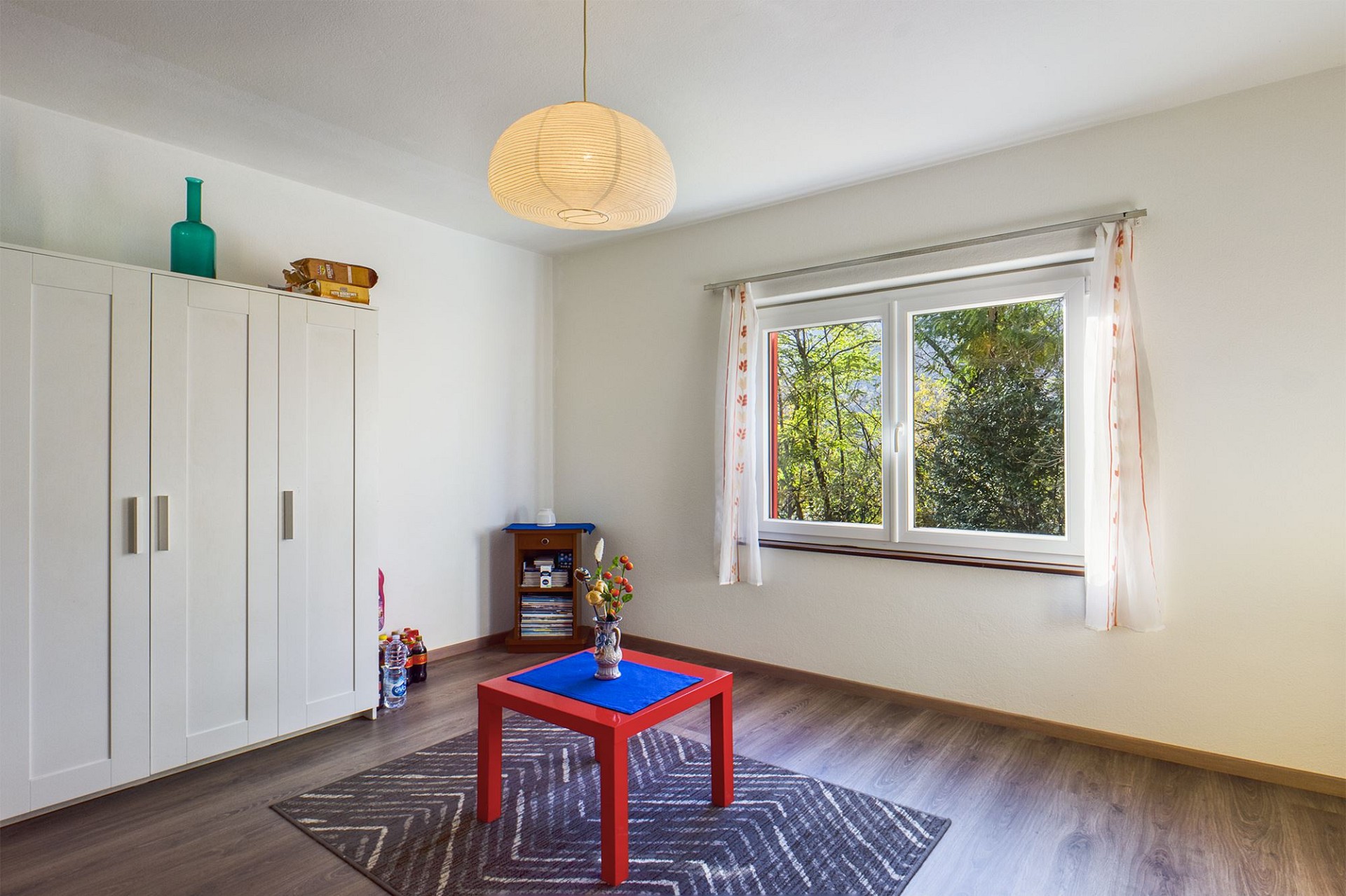 Helles Zimmer mit Fenster und Kleiderschrank