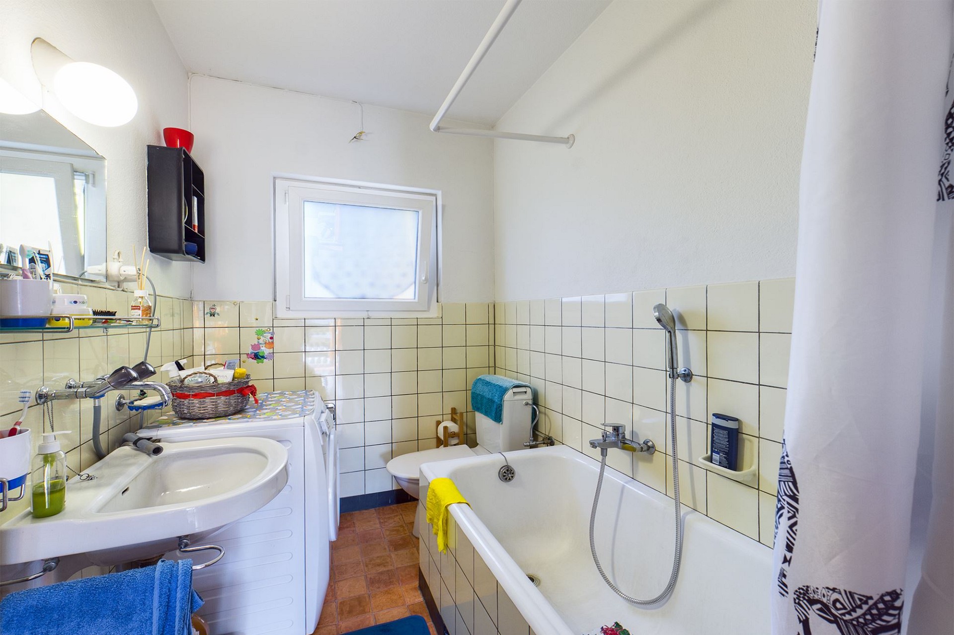 Kleines Badezimmer mit Badewanne und Waschbecken