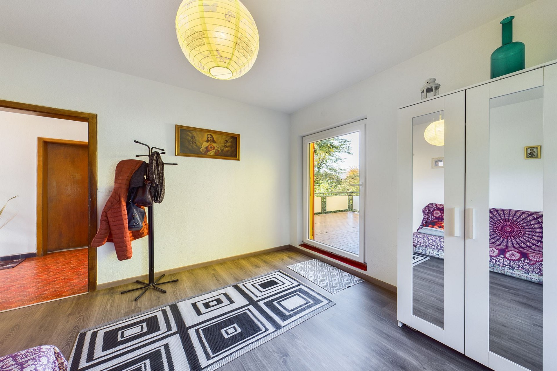 Heller Eingangsraum mit Fenster und Kleiderschrank