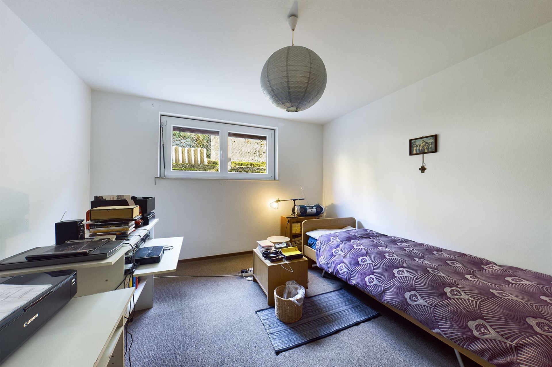 Ein kleines Schlafzimmer mit Einzelbett und Arbeitsplatz.